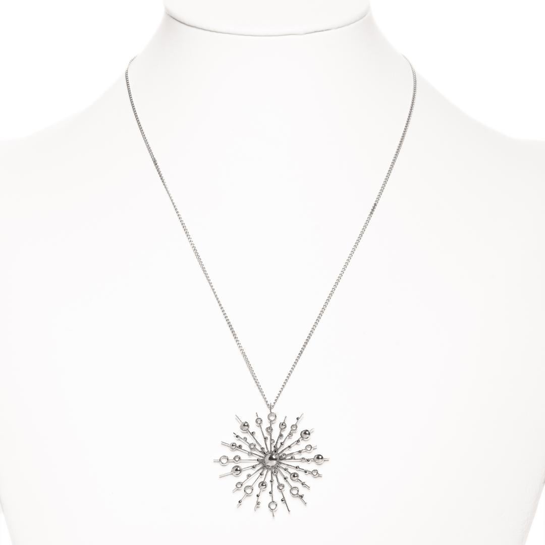Part of the 'Soleil' collection by Natalie Barney, this pendant necklace features a 40mm wide sunburst with smaller sunbursts on the chain. This pendant comes complete with a 45cm fine trace chain.

Made in Sterling Silver.  Please request the video