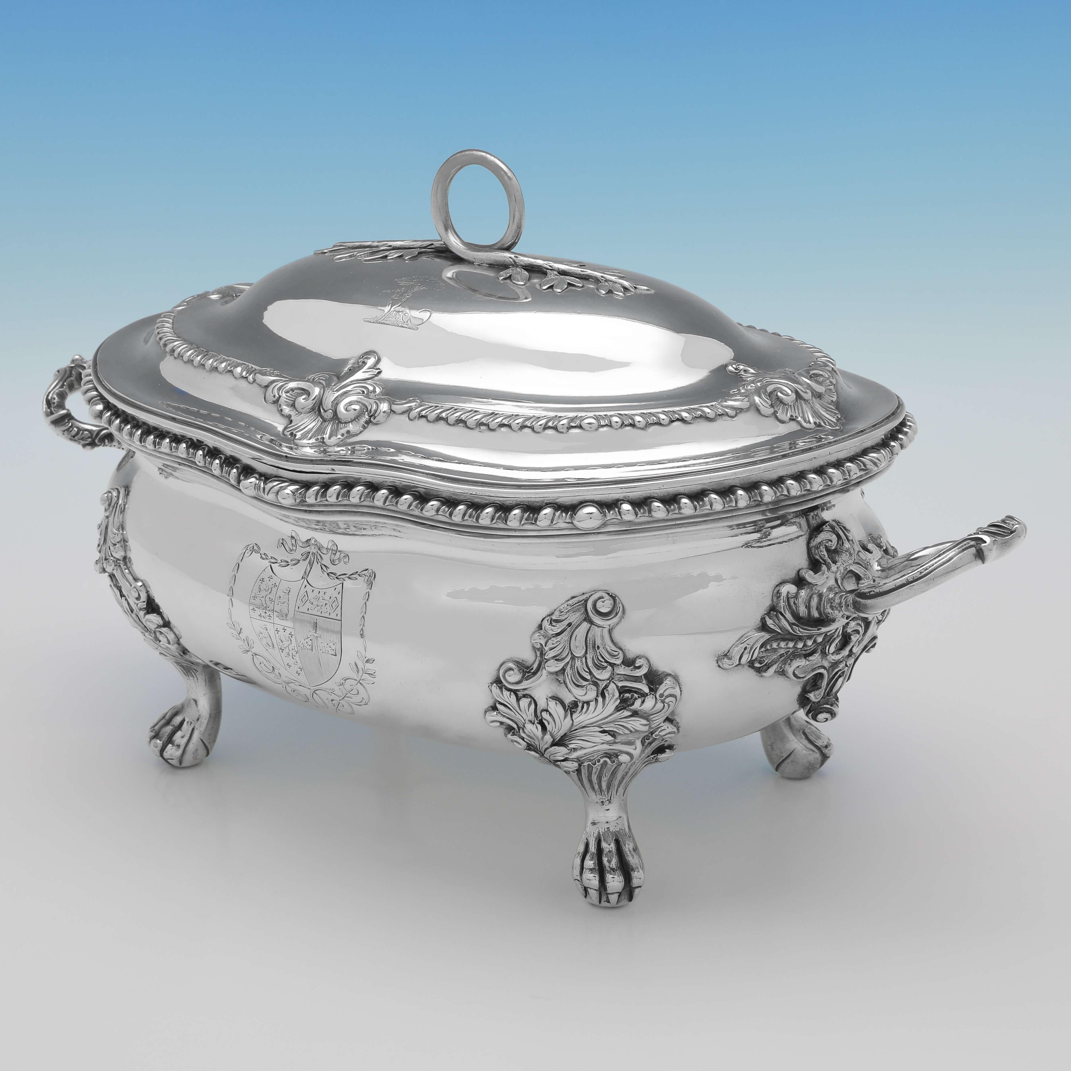 Hallmarked in London in 1766 by Charles Frederick Kandler, this striking, George III, Antique Sterling Silver Soup Tureen, features gadroon borders, ornate feet and handles, and is engraved with a coat of arms to the body and crest to the lid. The