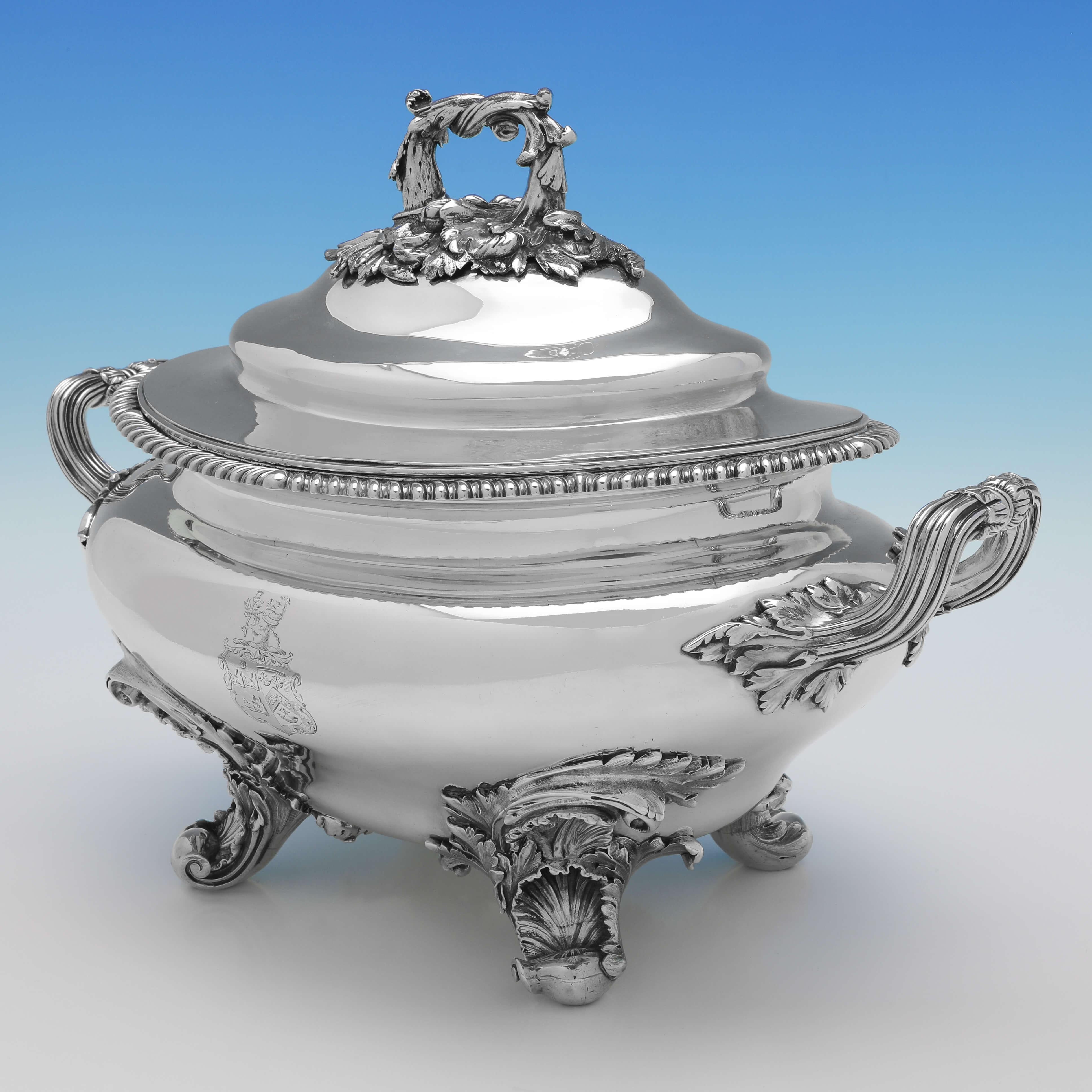 Hallmarked in London in 1835 by Barnards, this superb, William IV, Antique Sterling Silver Soup Tureen, features an ornate cast handle to the lid and ornate cast feet, a gadroon borders, and an engraved coat of arms to the side. The soup tureen