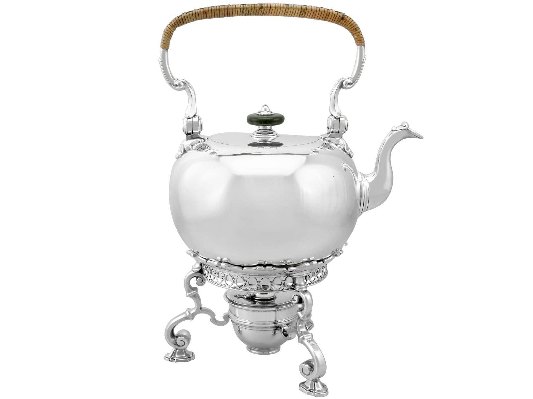 This magnificent and impressive antique Georgian sterling silver spirit kettle has a circular rounded form.
The surface of the Georgian silver kettle is plain and embellished with a contemporary engraved coat of arms encompassed with a scrolling