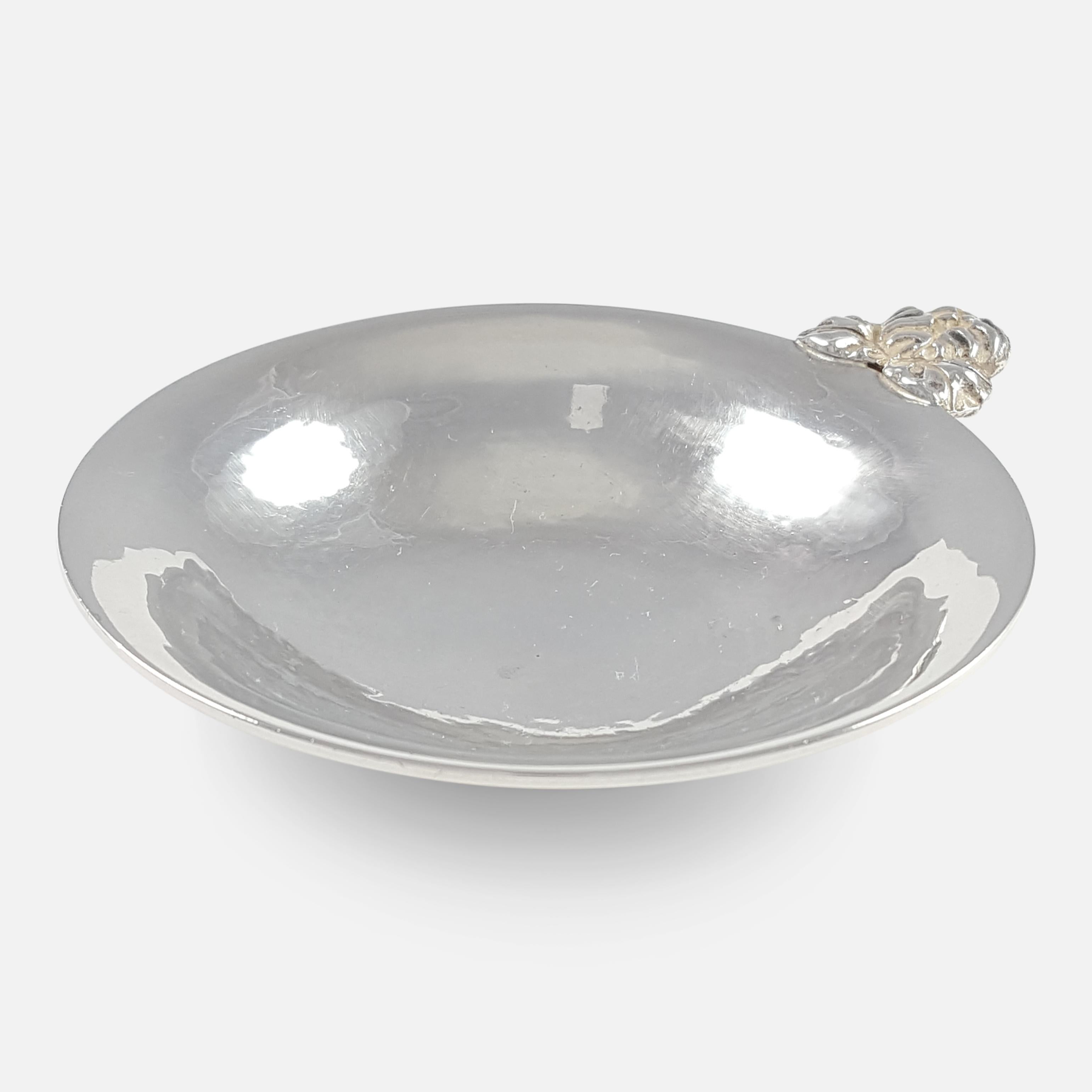 A George VI sterling silver wine taster with London hallmarks, and by Charles Boyton with facsimile signature. The surface of the bowl has a hammered finish, sitting on a circular base.

Assay: - .925 (Sterling Silver).

Date: -