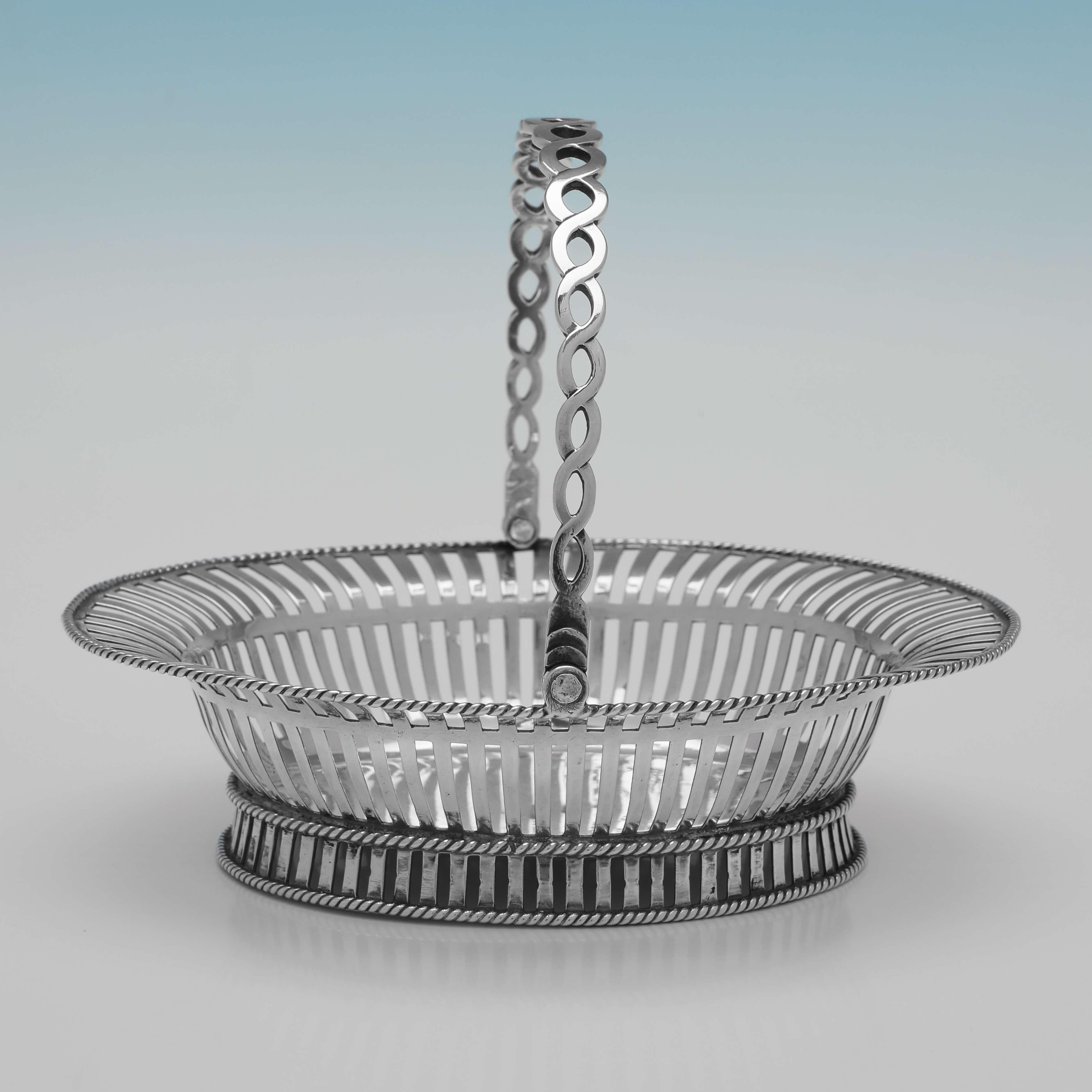 Hallmarked in London in 1753 by Edward Aldridge, this attractive, George II, Antique Sterling Silver Sweetmeat Basket, features slat piercing, rope borders, and a twist handle. The basket measures 4.25