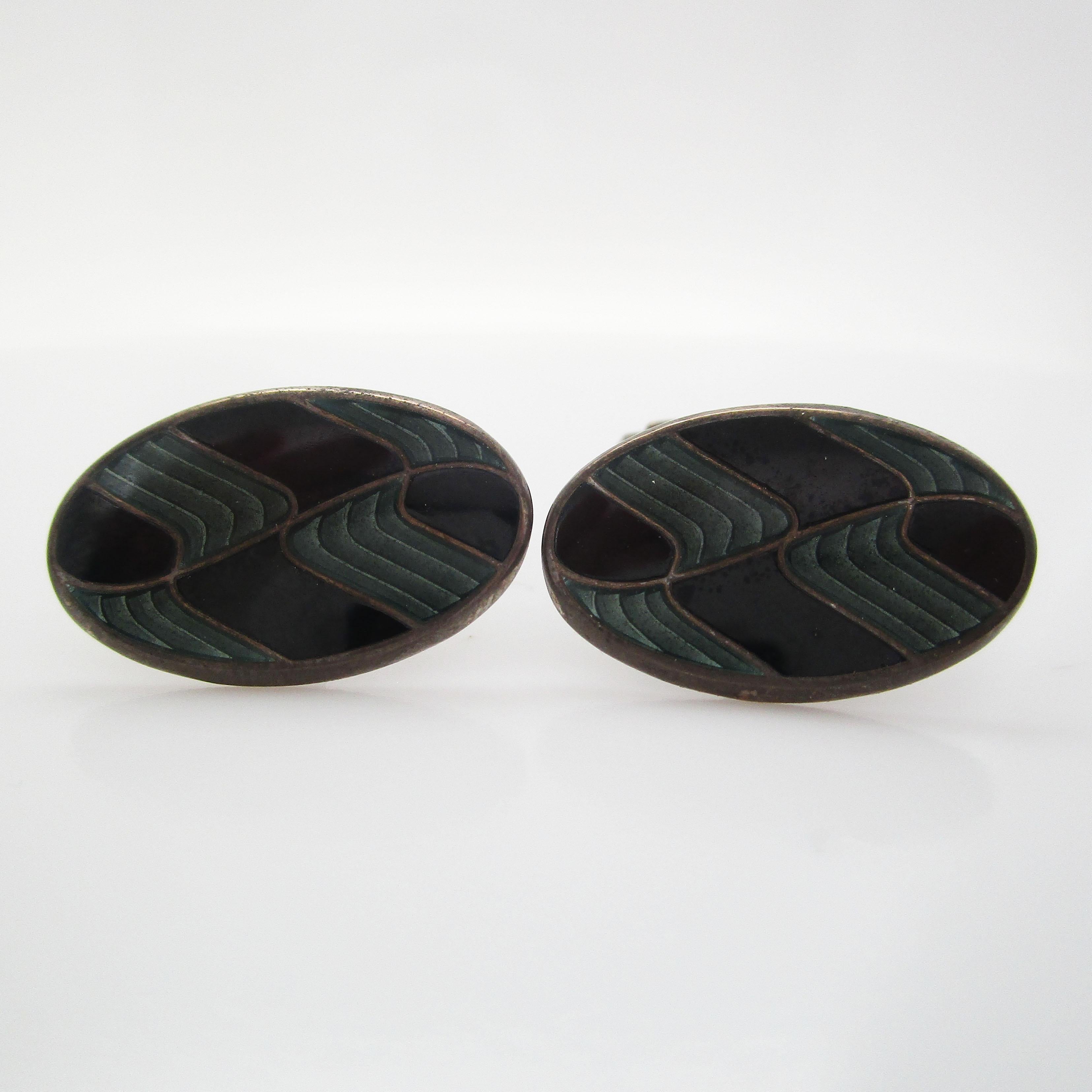 This is a fantastic pair of gentleman’s cufflinks in sterling silver with beautiful black and gray enamel panels. The enamel is in an elegant wave design that creates the perfect picture of distinguished excellence that every gentleman strives for.