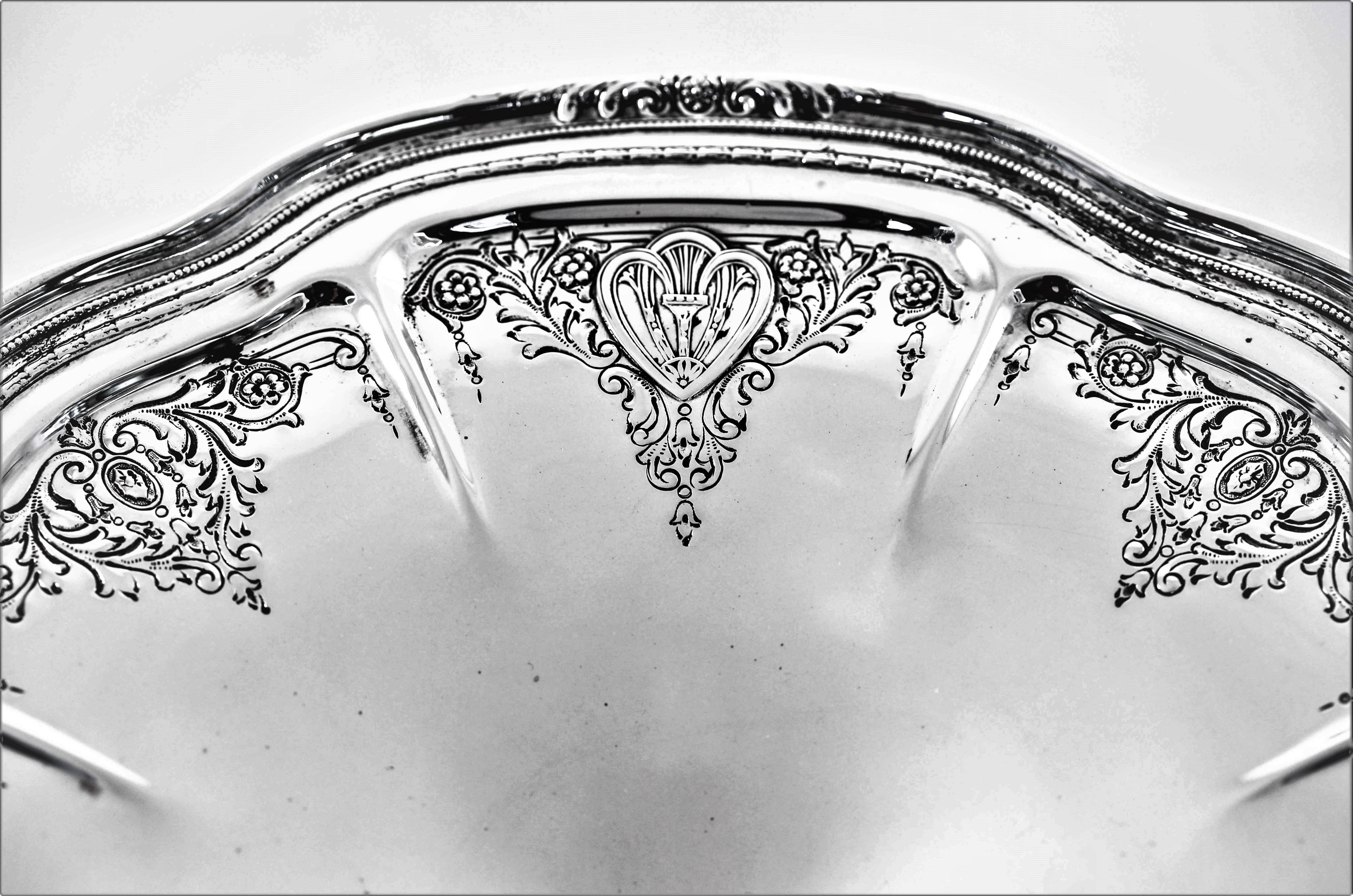 A lovely tazz to use when entertaining. It has a scalloped edge with indentations. Along the inside, eight sets of etched flowers and garlands can be found between each ridge. There is a medallion like design on each alternative one. A rich and