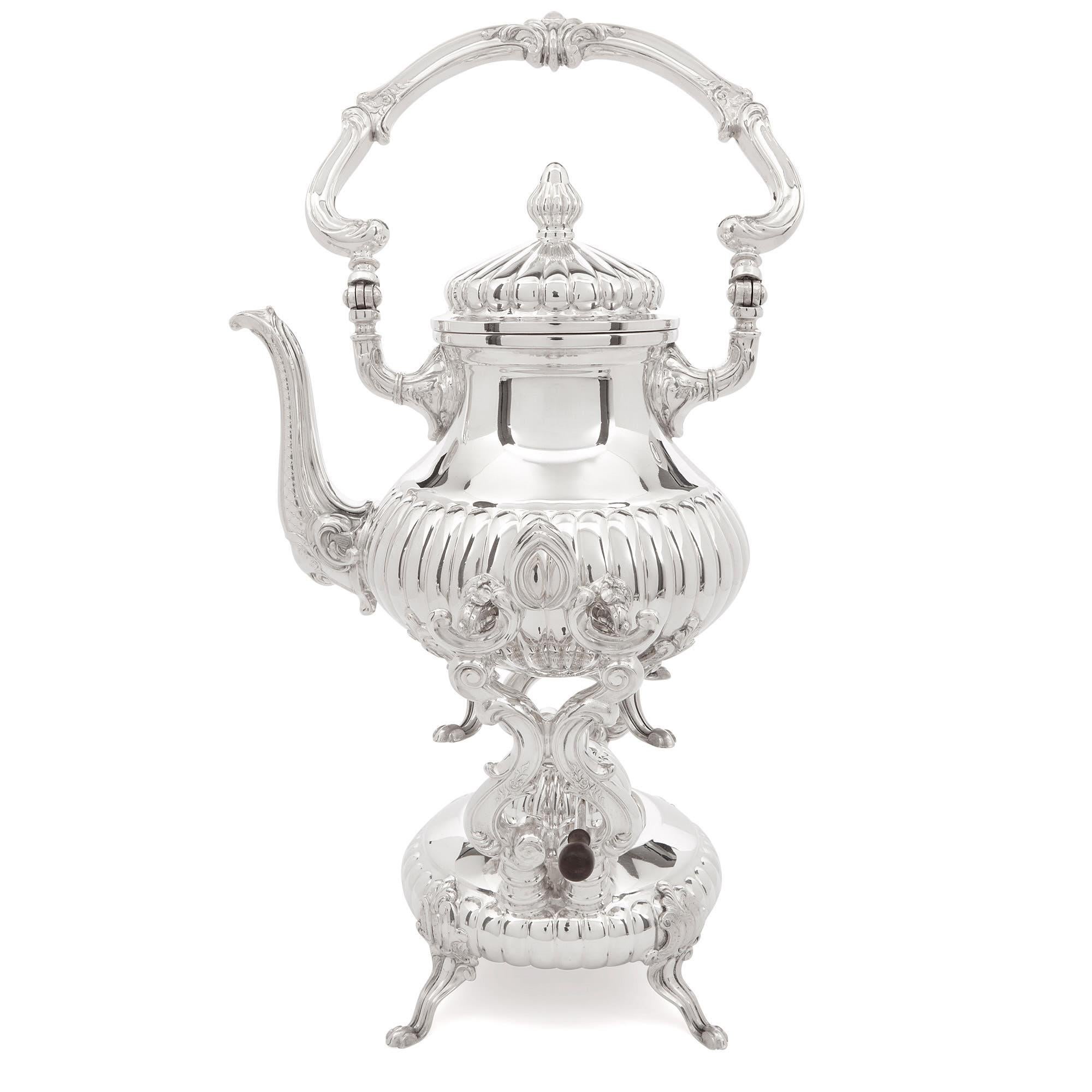 This sterling silver tea and coffee set is comprised of a tray, a kettle with a burner stand, a tea and coffee pot, milk jug, sugar bowl and a tea strainer in a bowl. The set is fully hallmarked and inscribed, ‘STERLING 975/CAMUSSO/MADE IN PERU’.
