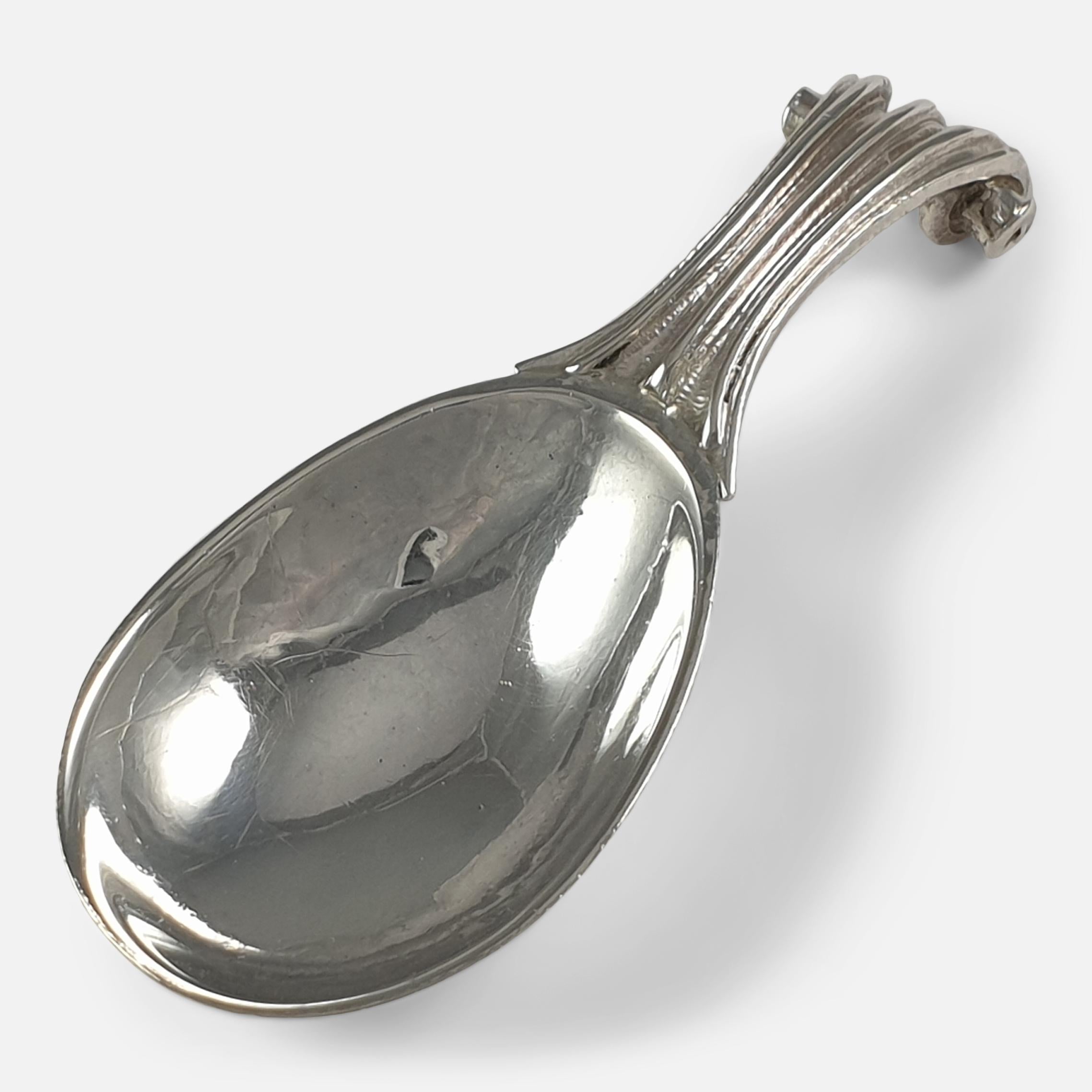 An Arts & Crafts sterling silver tea caddy spoon. The tea caddy spoon has a spot-hammered bowl, and fluted Onslow-style handle. 

Made by the silversmith Omar Ramsden, and hallmarked Birmingham, 1927.

Assay: - .925 Sterling Silver.

Date: -
