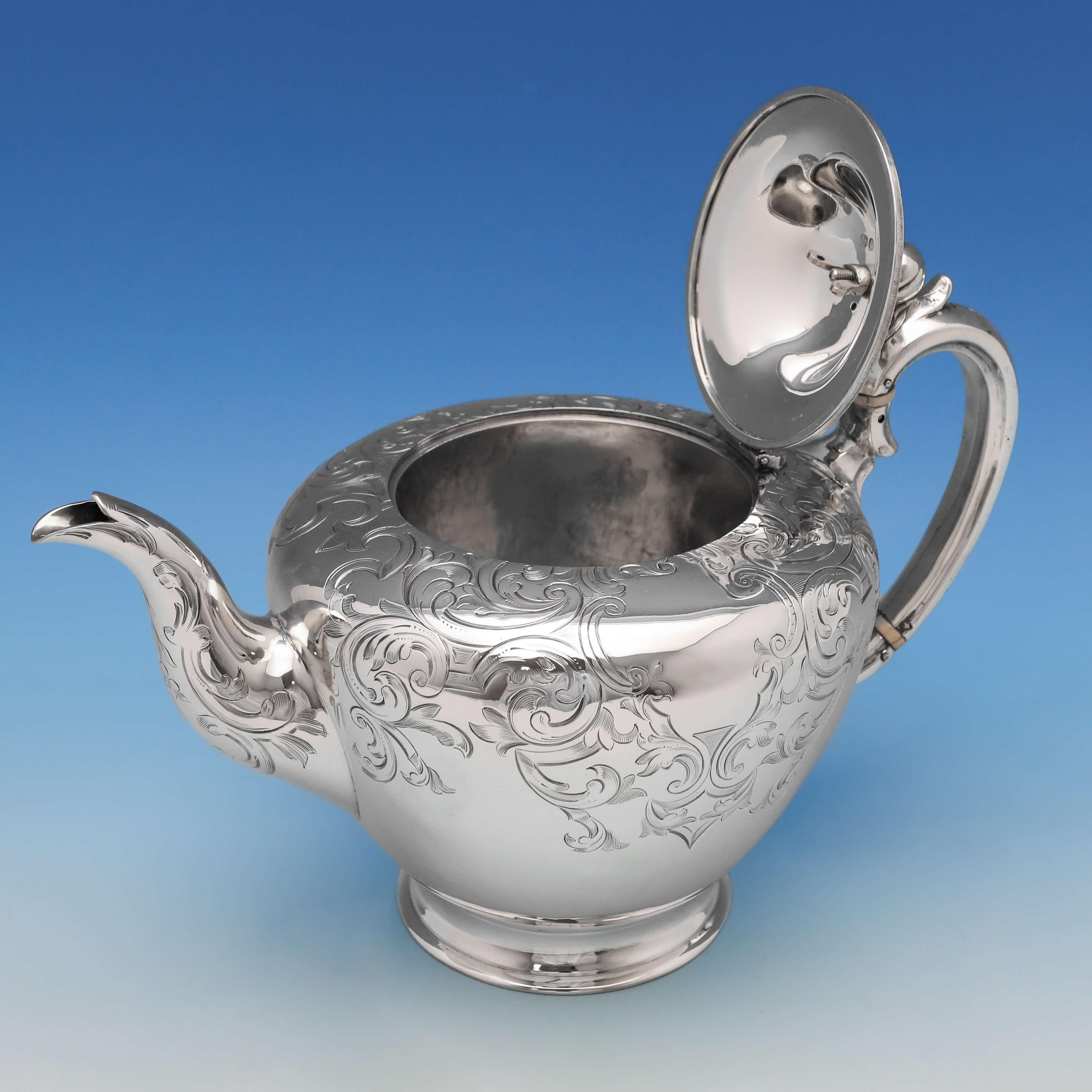 Hallmarked in London in 1850 by George Burrows II & Richard Pearce, this attractive, Victorian, antique sterling silver teapot, features engraved decoration throughout, a pumpkin shaped finial, and a silver handle with ivory breakers. The teapot
