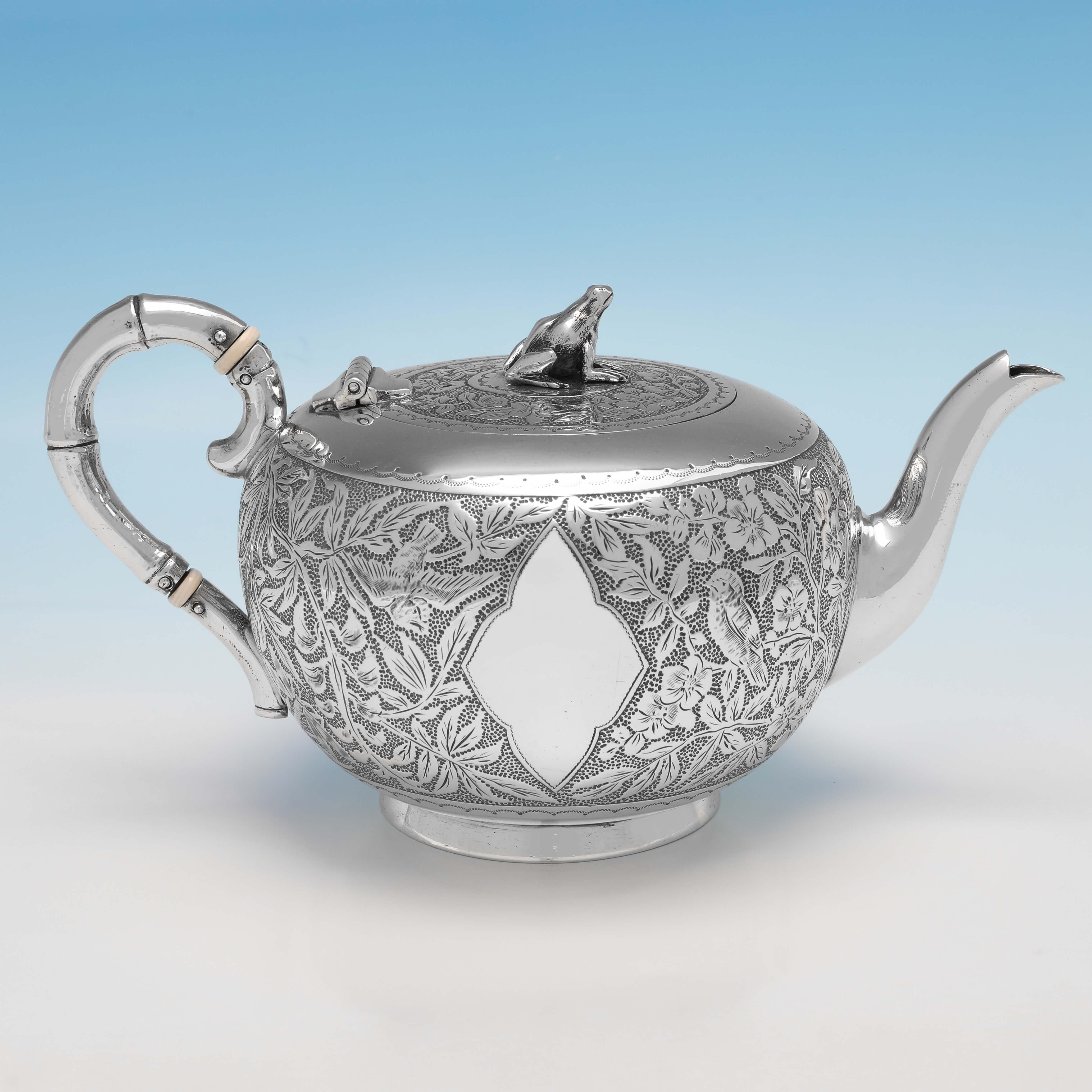 Hallmarked in London in 1890 by Goldsmiths Alliance, this attractive, antique Sterling Silver teapot, is in the Aesthetic taste, featuring chased and engraved decoration to the body, a bamboo designed handle, and a frog finial. The teapot measures