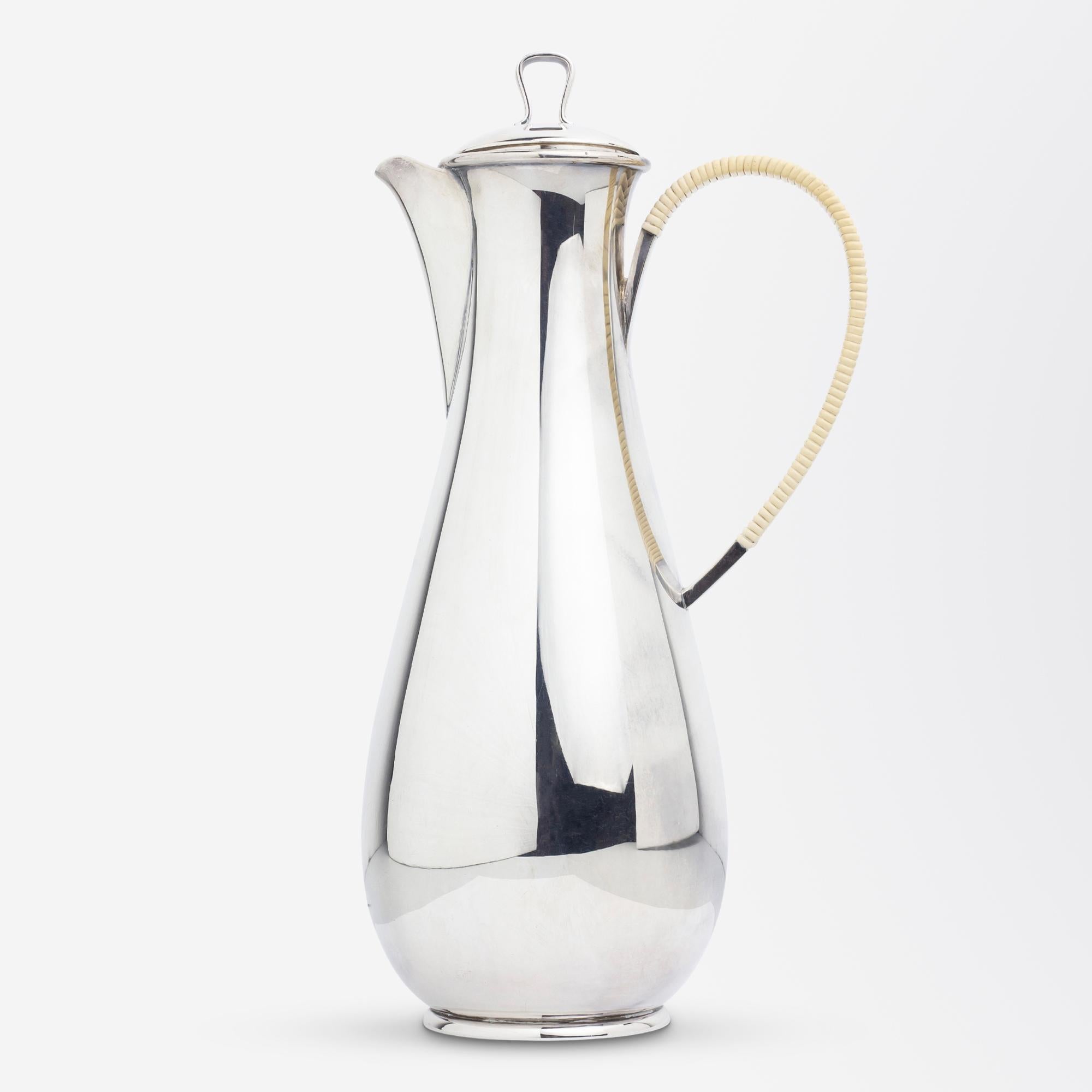This three piece sterling silver coffee set was designed by Sigvard Bernadotte and manufactured by Georg Jensen. The elongated set is known as pattern '967' and is one of the more scarce designs by Sigvard Bernadotte, accented with a woven
