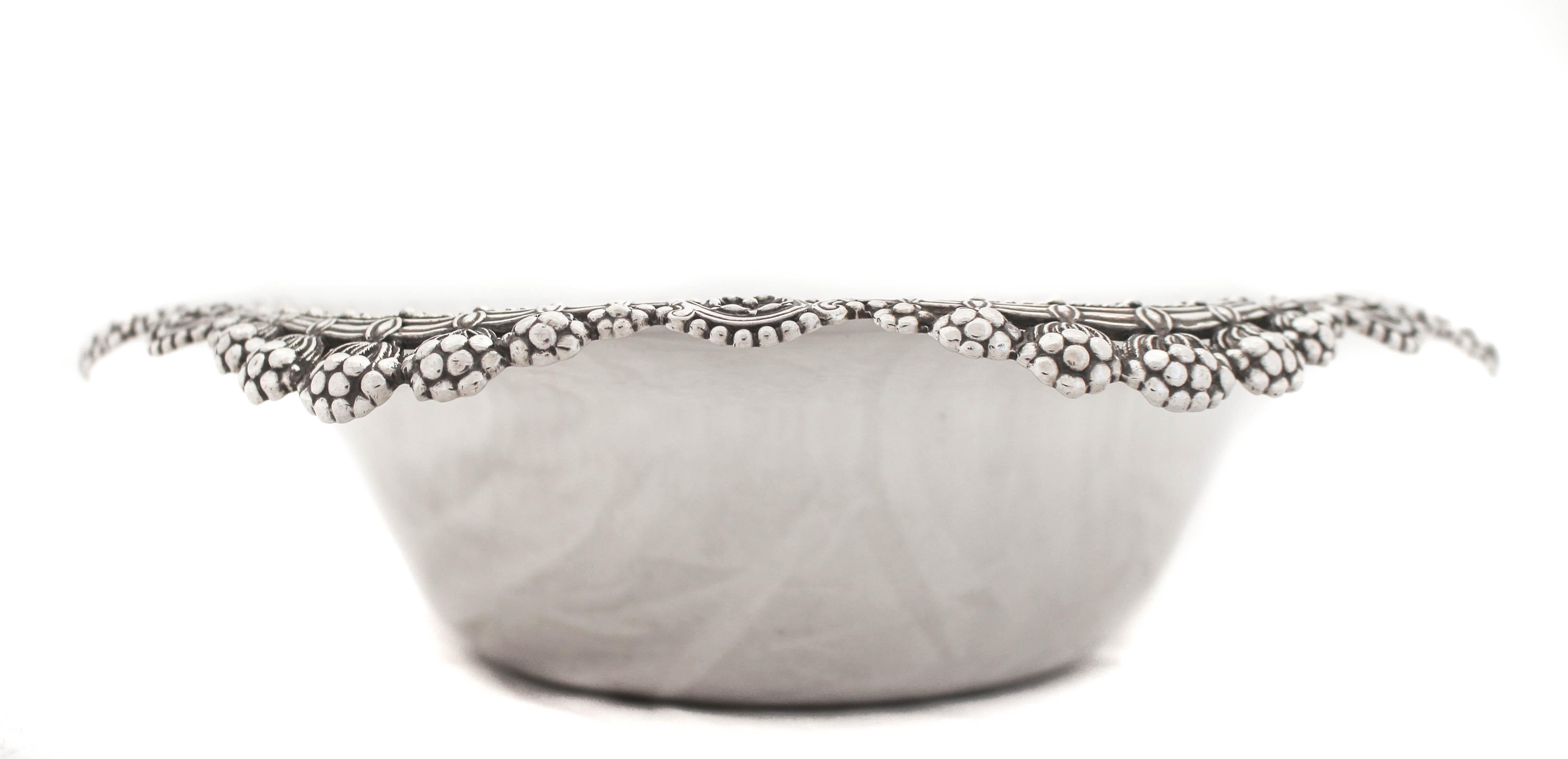 Nous vous proposons un bol en argent sterling de la société Tiffany and Company, de renommée mondiale.  Le bord festonné est orné d'un motif Art nouveau.  Sept bouquets de fleurs sont suspendus au bord de chacun des sept panneaux.  Au centre se