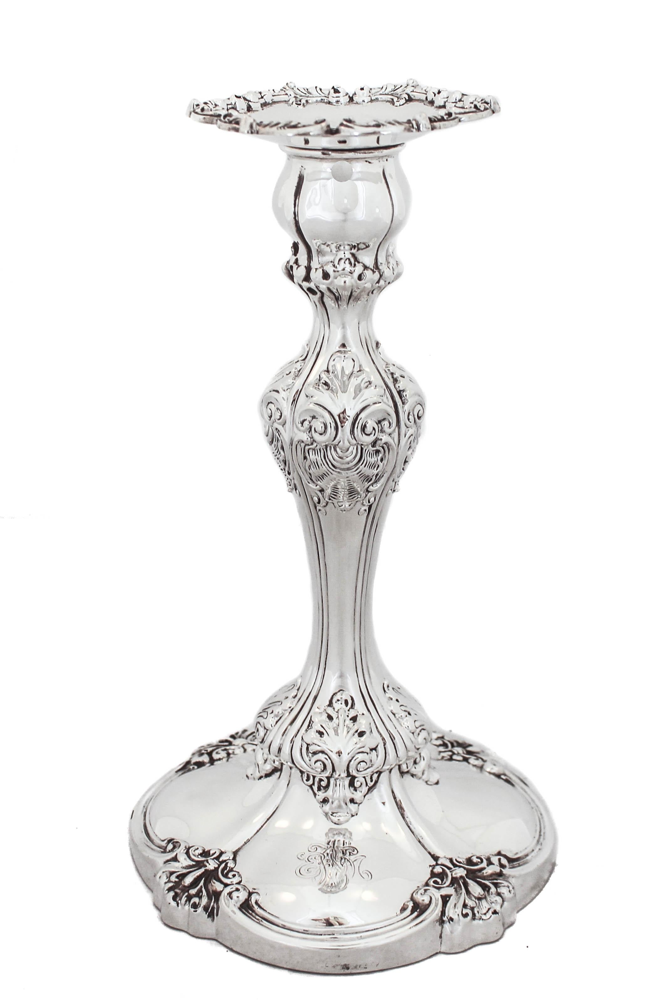 Being offered is a pair of sterling silver candlesticks by the world renowned Tiffany and Company.  They have a rich old-world design and are very prominent.  The base is scalloped and has four ornamental indentations.  That same work is found
