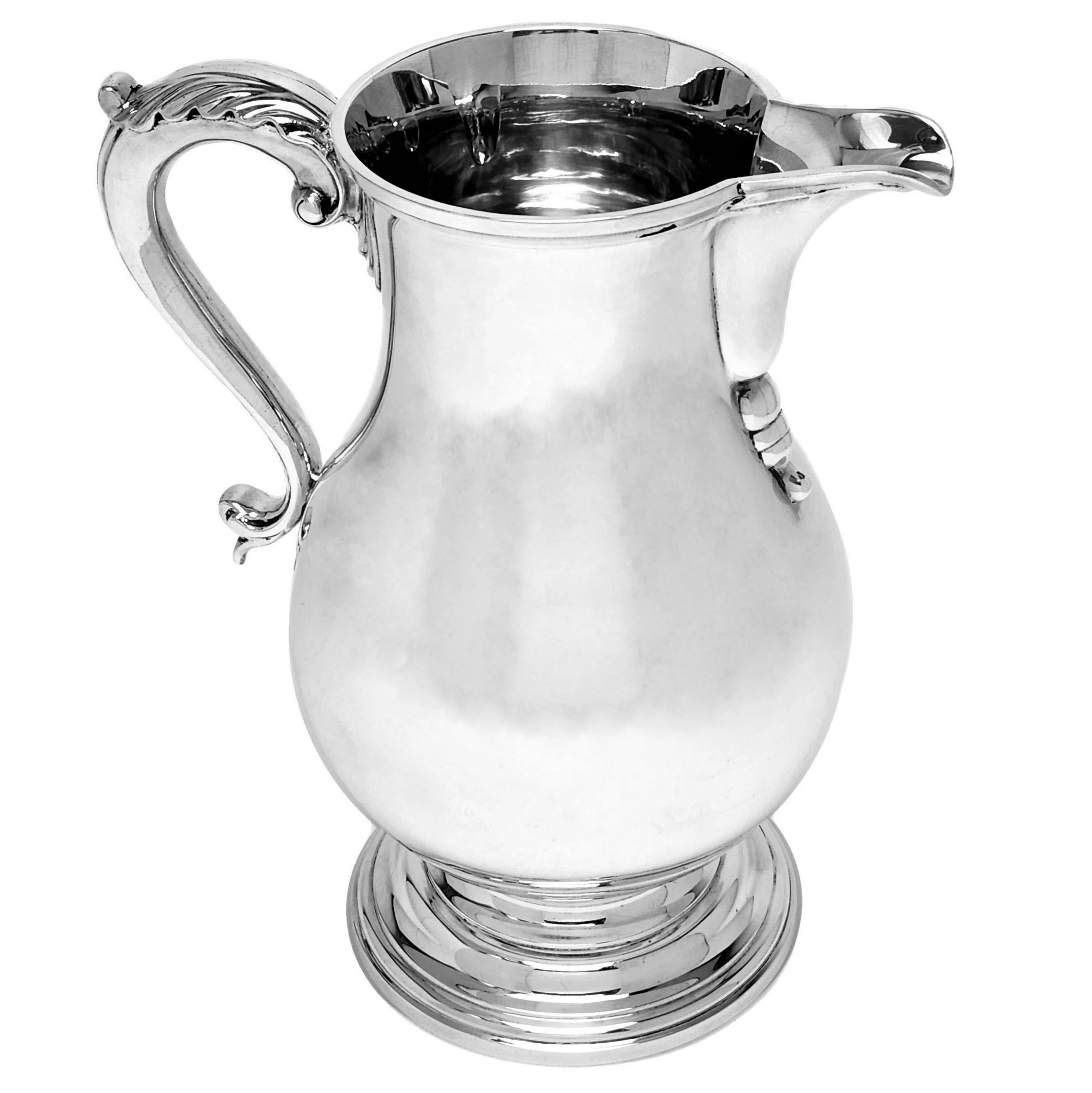A impressive Tiffany & Co Solid Silver Pitcher Jug in the simple, elegant style of a 18th century Georgian Beer Jug. The Jug has a baluster shaped body on a stepped pedestal foot with an acanthus leaf topped scroll handle. Of substantial size, this