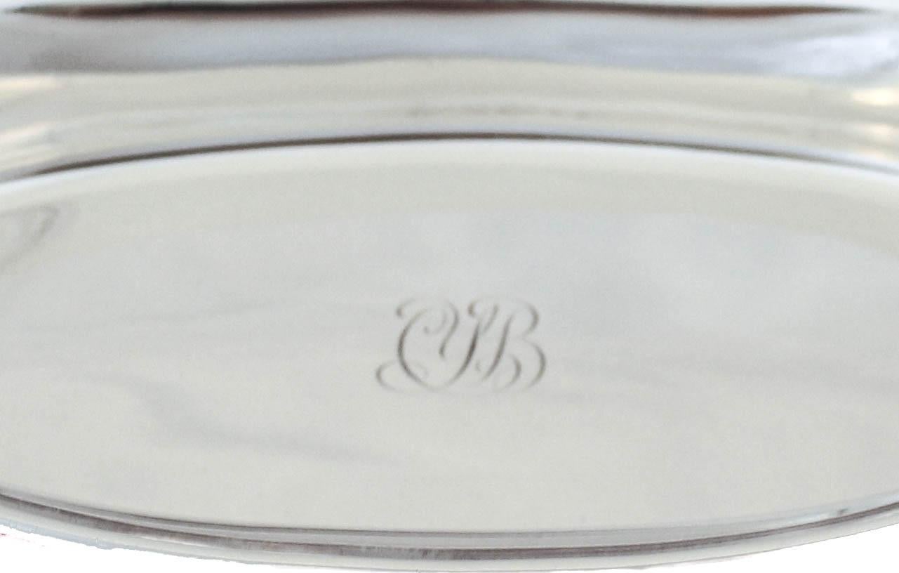 We are delighted to offer you this sterling silver dish by the world renowned Tiffany & Company. It has a canoe-like oval shape with curled handles on the end. In the center there is a hand engraved monogram. The right size for sweets or cookies.