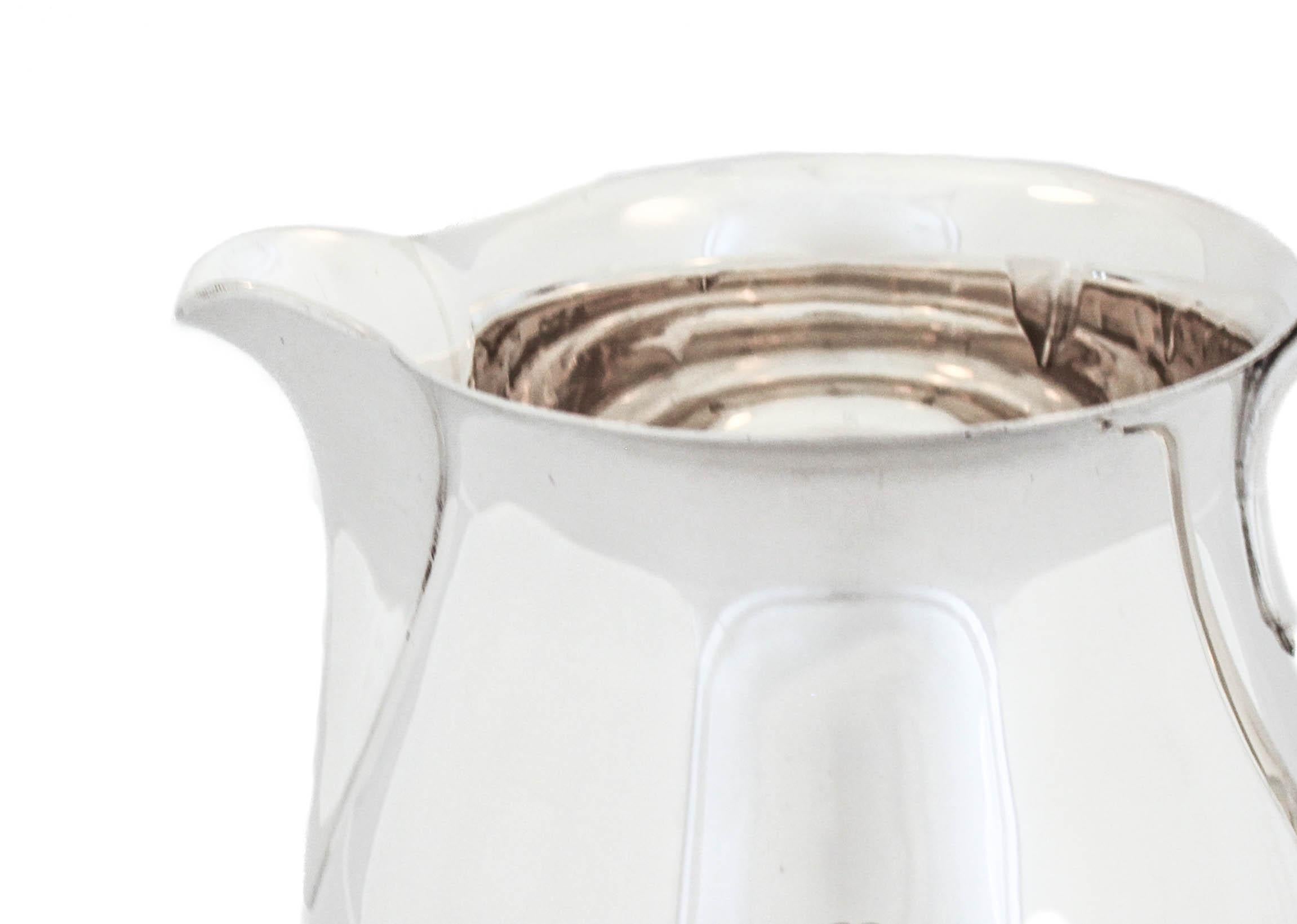 Being offered is a sterling silver water pitcher by the world renowned Tiffany and Company, hallmarked 1921.  It has a federalist shape and design and no decorative features, in keeping with the early American federalist style.  It holds 3 3/4 pints