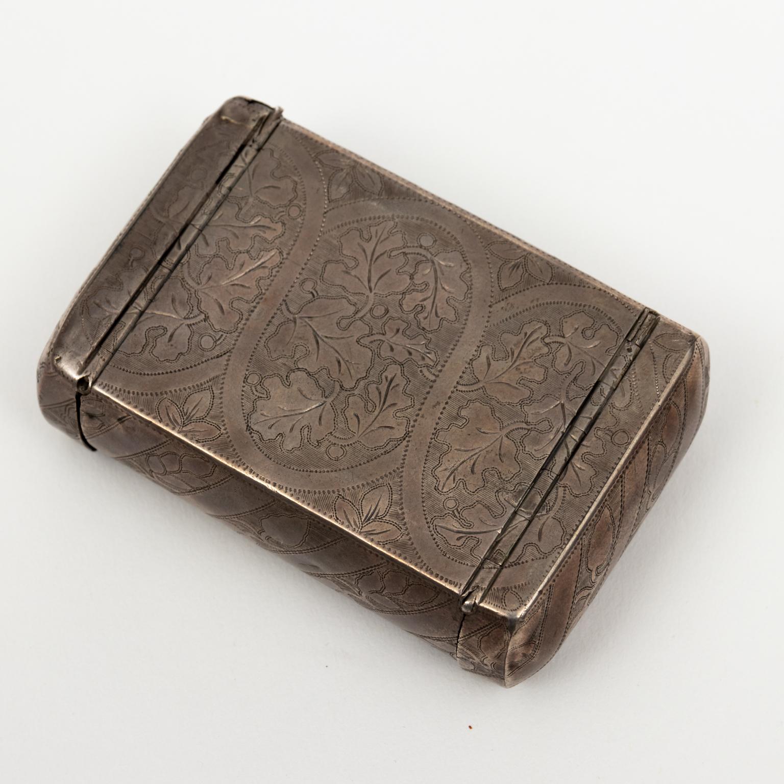Floral etched etui or tinderbox with vinaigrette, fold out light strike, and tinder compartments, circa 1800s. The piece is composed of sterling silver with gold wash. Please note of wear consistent with antique age including patina and oxidation.