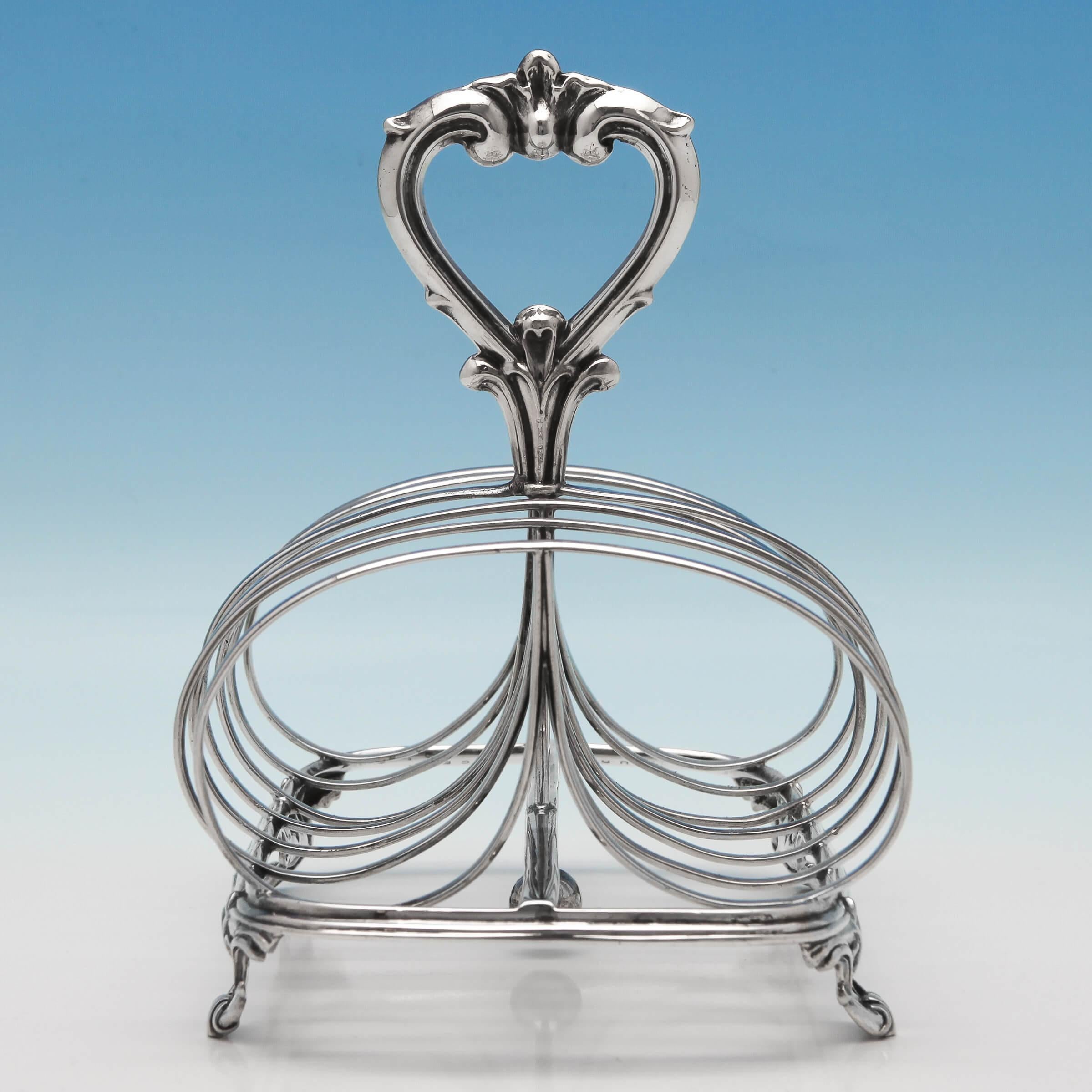 Hallmarked in London in 1874 by William Evans, this fine, Victorian, Antique, Sterling Silver Toast Rack has wide, loop slots, a decorative scroll handle and cast, scroll feet. The toast rack measures 5.5