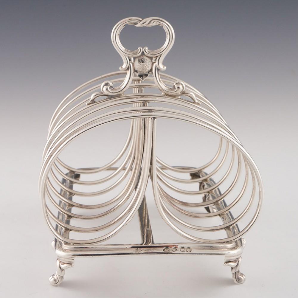 Heading : Sterling silver toast rack
Date : Hallmarked in London in 1852 for Edward and John Barnard
Period : Victoria
Origin : London, England
Decoration : Six double loop divisions with scrolled acanthus leaf handle, four scrolled feet
Size : 