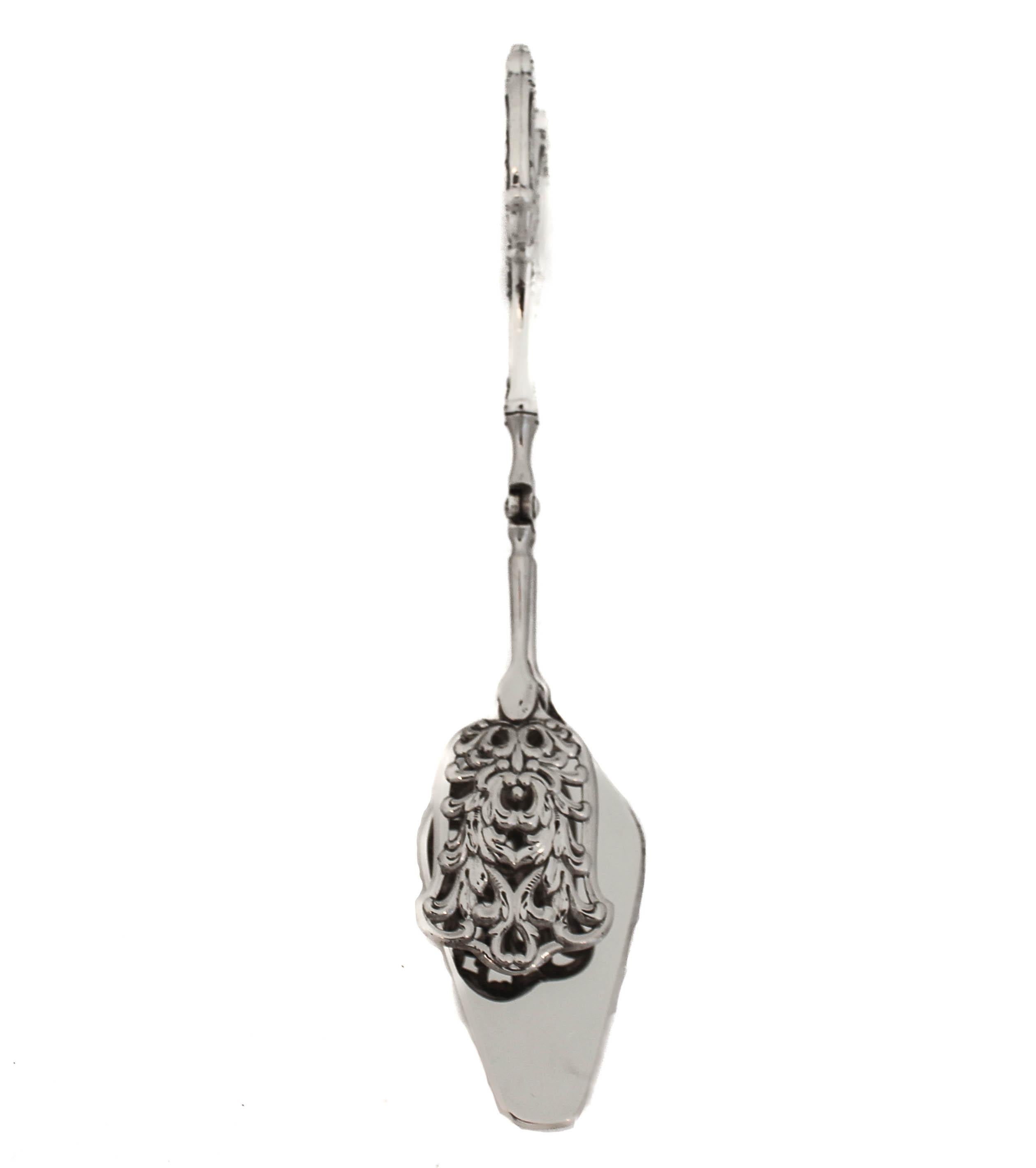 Se ofrece una pinza de plata de ley fabricada por Webster Silver.  Se puede utilizar para carne, aves, pescado, verduras y quiche.  Incluso en tu mesa de postres para petit four, tarta o fruta.  Un lado es plano para sujetar lo que estés cogiendo,