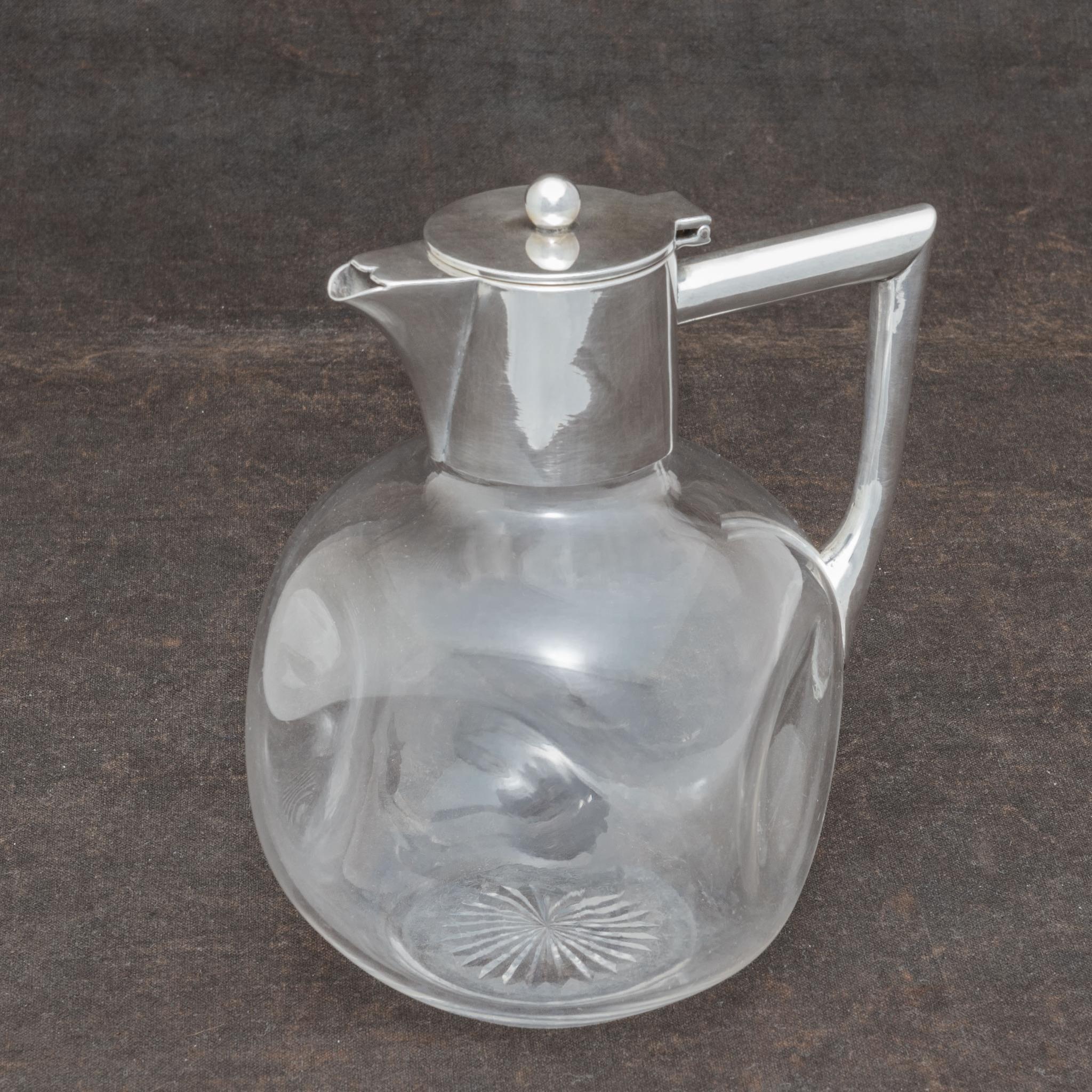 Stylish late nineteenth century claret jug with a hand blown spherical glass body incorporating a dimpled design. The silver handle and top combination are hallmarked Birmingham 1898. Deceptive in that, although modest looking in size, it will hold