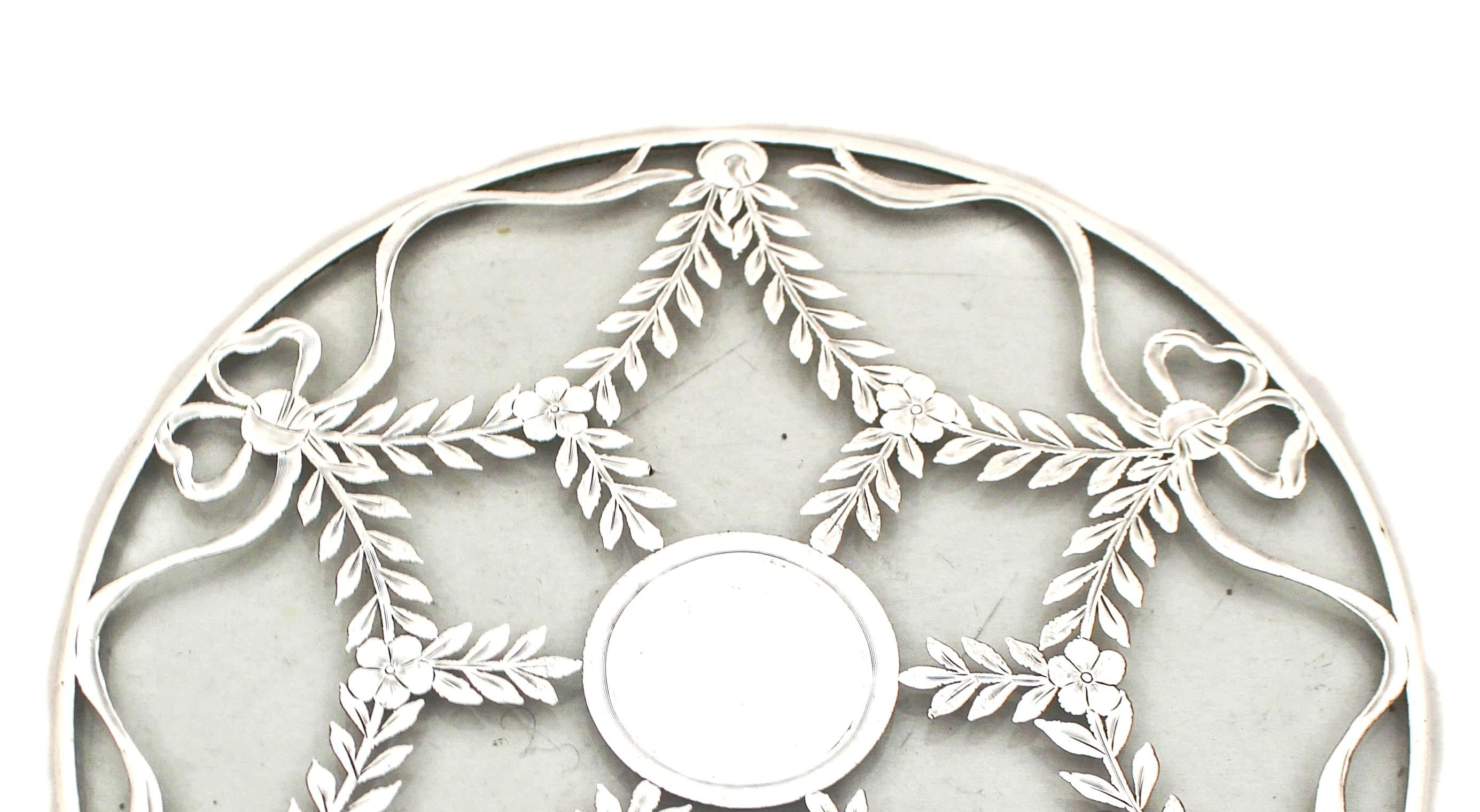 Being offered is this sterling silver trivet by Webster Silver. It has wreaths and bows decorating the top with a round cartouche for a monogram.  A large size trivet for something bigger than the usual size.  In mint condition.