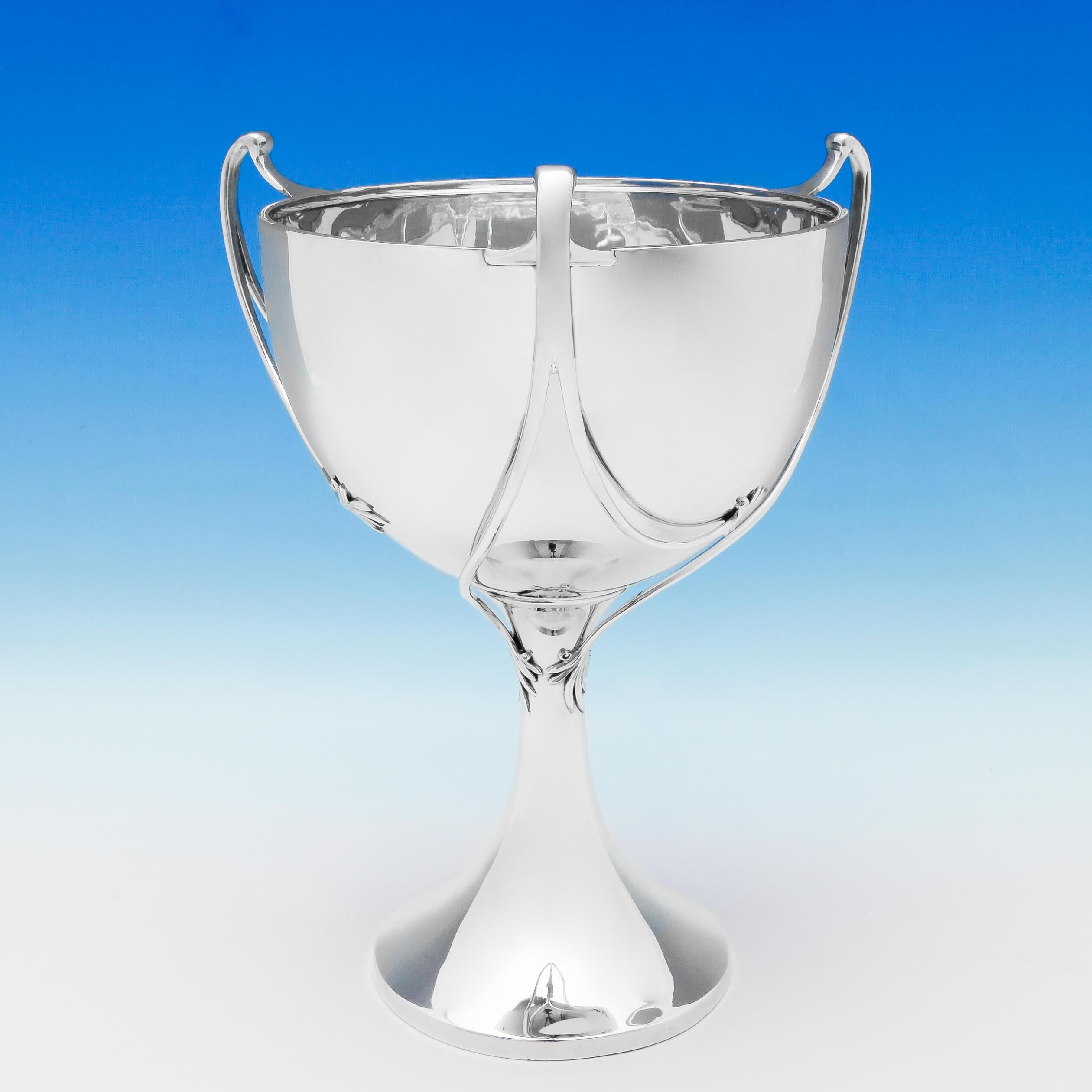 Hallmarked in London in 1927 by William Bruford & Son, this stylish, George V, Sterling Silver Trophy Cup, is elegant and simple in design, featuring three swirling handles with naturalistic terminals. The trophy cup measures 13