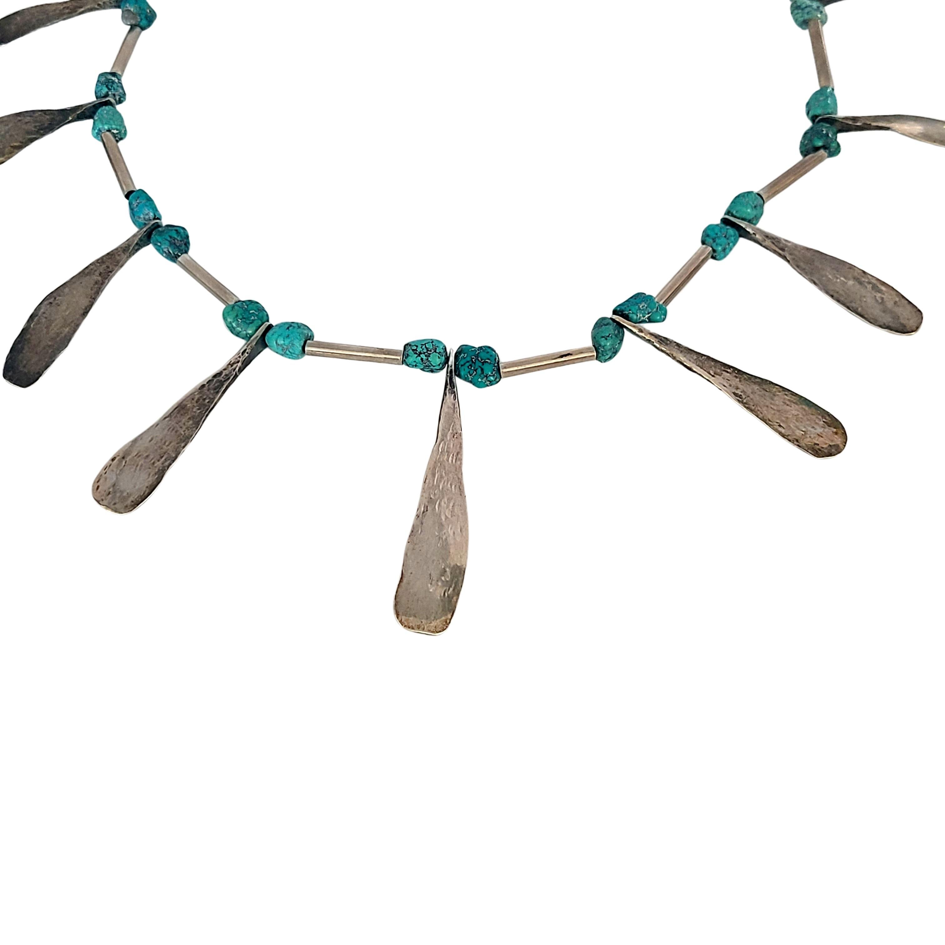 Silver and turquoise bead necklace.

This necklace features long silver barrel beads with turquoise beads and hammered silver teardrop dangles.

Measures approx 26 1/2