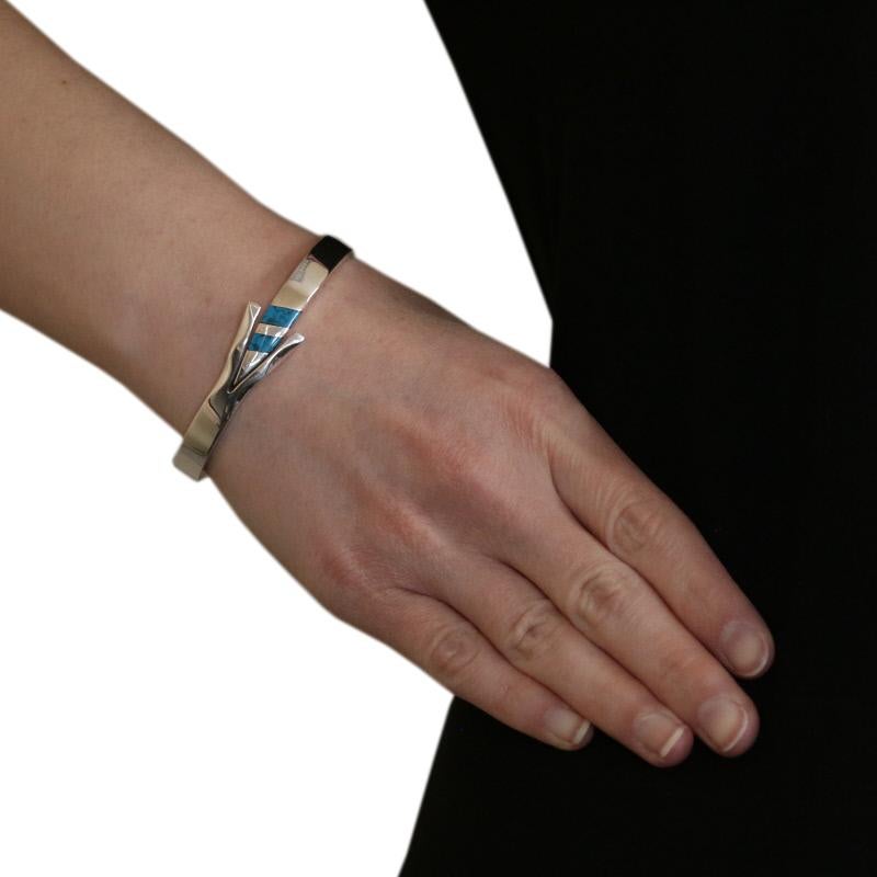 Country of Origin: Mexico
 Metal Content: Guaranteed Sterling Silver as stamped
 
 Stone Information: 
 Genuine Turquoise
 Treatment: Routinely Enhanced
 
 Style: Bangle
 Measurements: 6 3/4