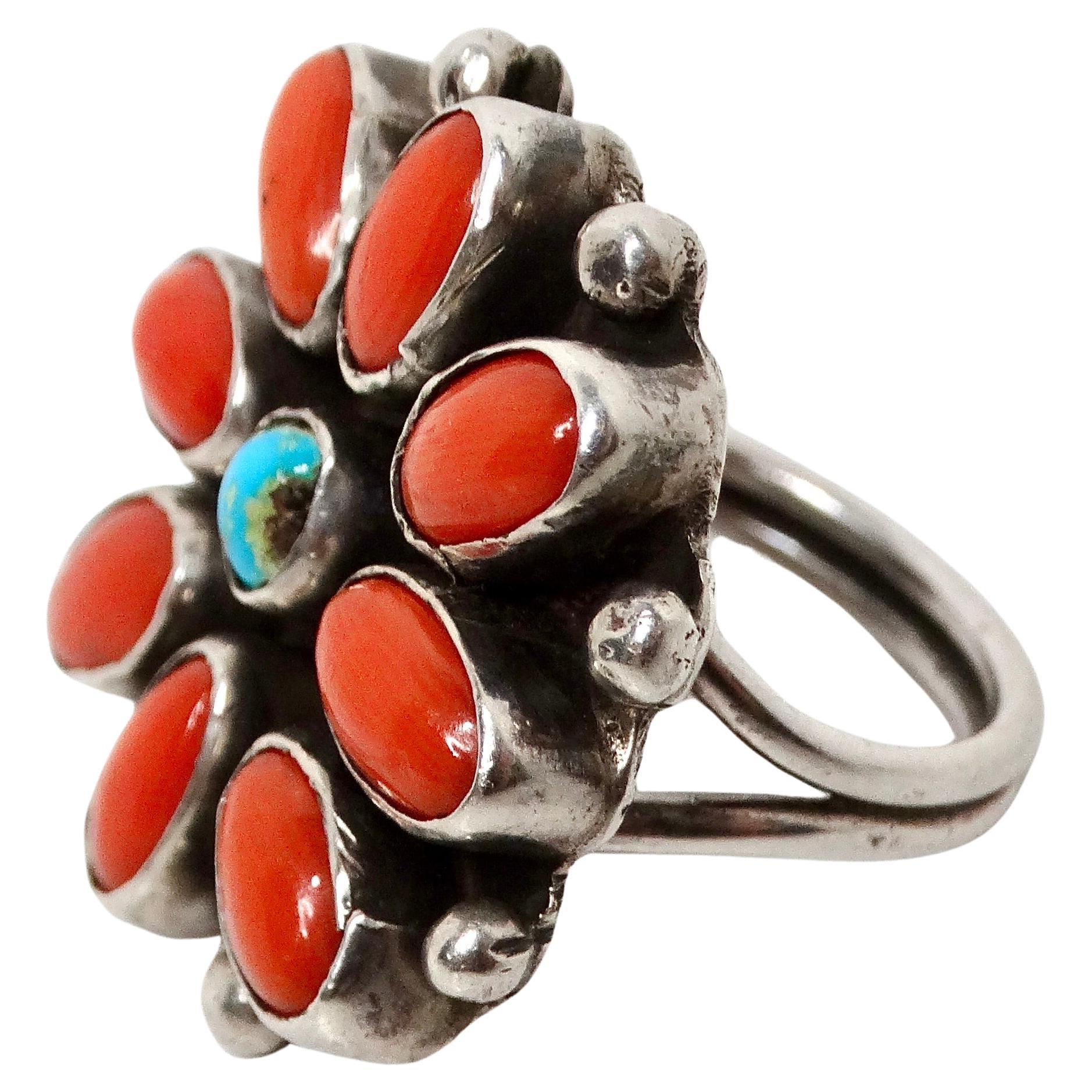 La bague en argent sterling à motif de fleur en turquoise et corail, datant des années 1970, est une pièce remarquable qui met en valeur l'art et le savoir-faire de la joaillerie amérindienne. Cette bague vintage présente un motif floral détaillé en