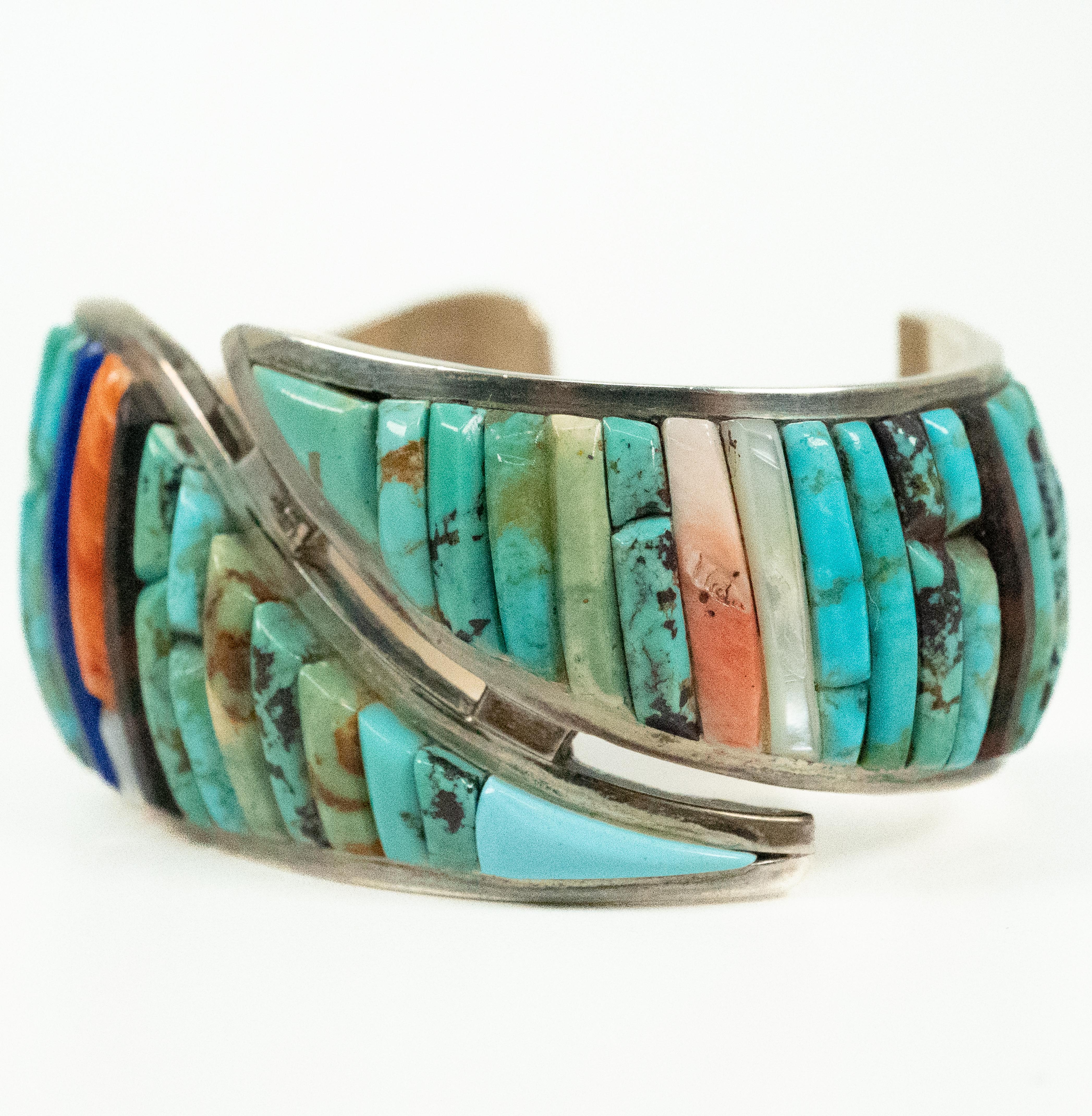 By famed Native American designer Pete Sierra, this unusual sterling silver cuff bracelet features turquoise, lapis lazulli, coral and mother of pearl.