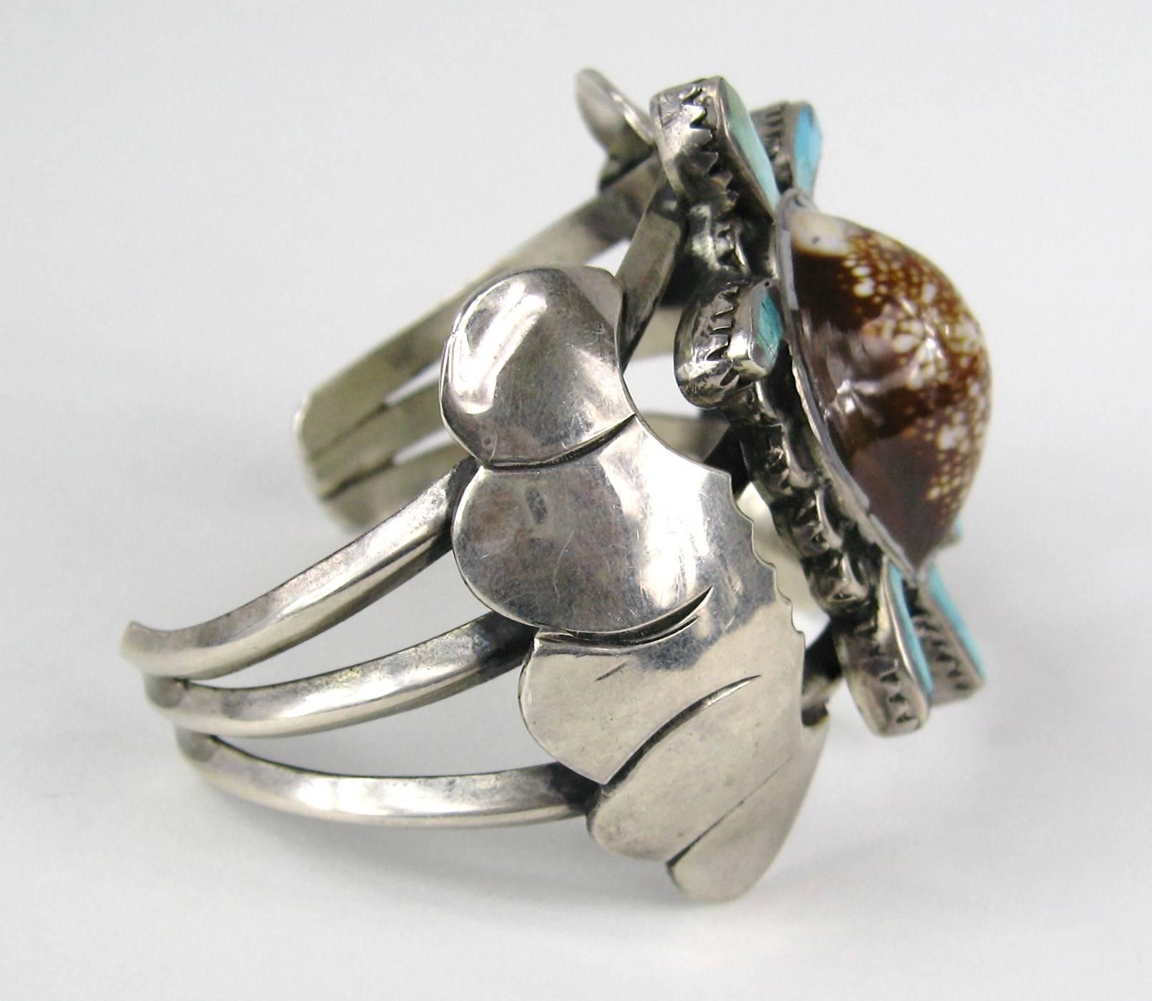 Hand wrought Sterling Silver Navajo Turtle Bracelet by E.A Zunie. Turtles body is Shell with Turquoise with a 3 Ring Bracelet surround. Matching Squash Blossom Necklace and Ring as well are on our storefront. Will Fit a 6.5in to 7.5in wrist. It is