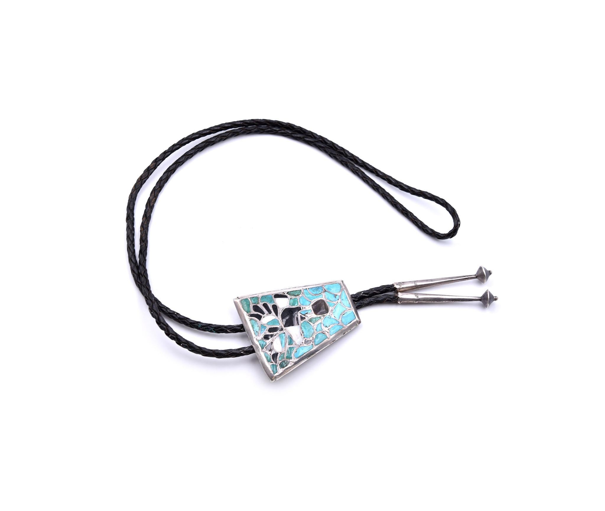 Designer: custom design hallmarked “Bennett”
Material: sterling silver
Gemstones: turquoise, mother of pearl, and onyx
Dimensions: tie measures 19 inches in length and pendant measures 60mm x 50mm
Weight: 45.09 grams
