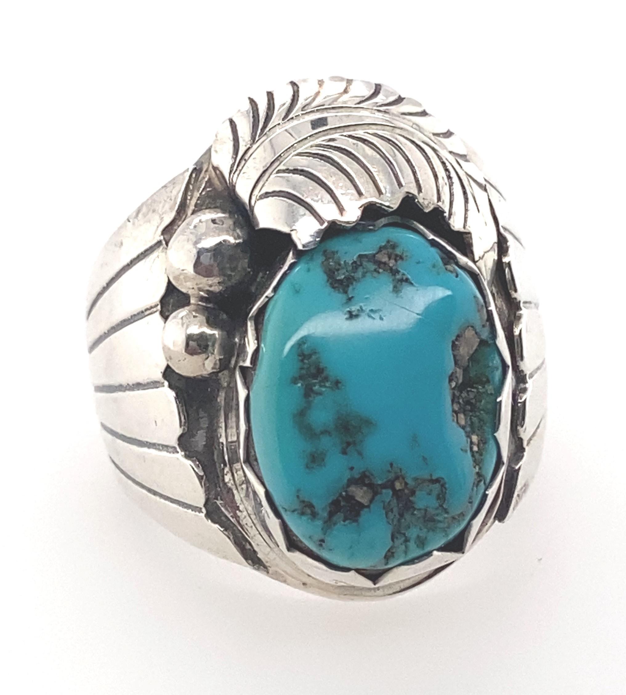 Dieser Ring ist ein schönes Beispiel für den Schmuck des geschätzten Navajo-Künstlers Dan Whitegoat. Der in den 1970er Jahren geschaffene, asymmetrisch gestaltete Mittelteil ist mit einem leuchtend blauen Türkisstein mit natürlicher Matrix besetzt.