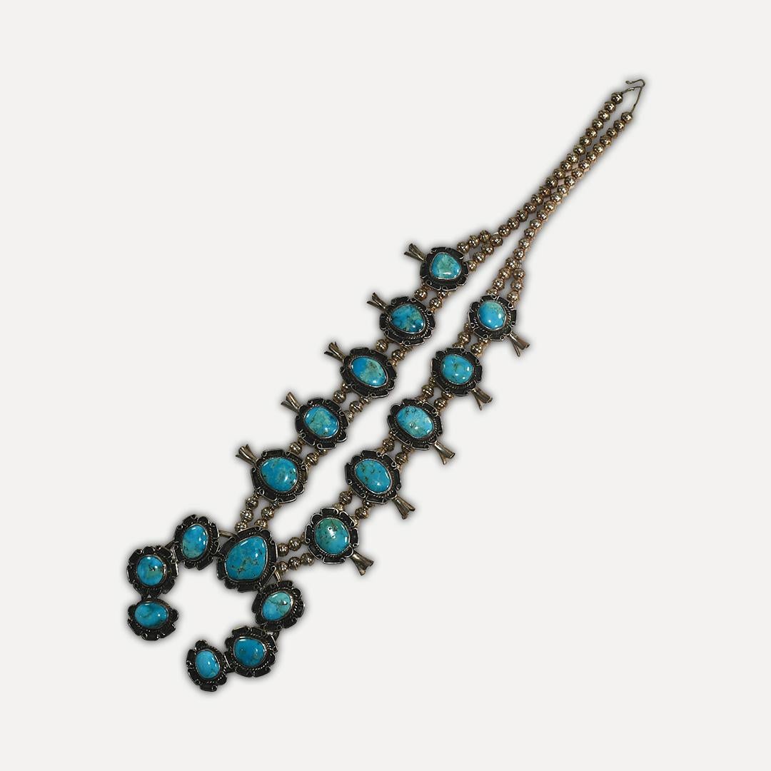 Native American squash blossom turquoise and sterling silver necklace.
Weighs 190 grams gross weight. Beautiful blue color on the turquoise stones.
The side turquoise settings measure 1 1/2 inches by 1 inch.
The pendant measures 3 inches by 3 1/4