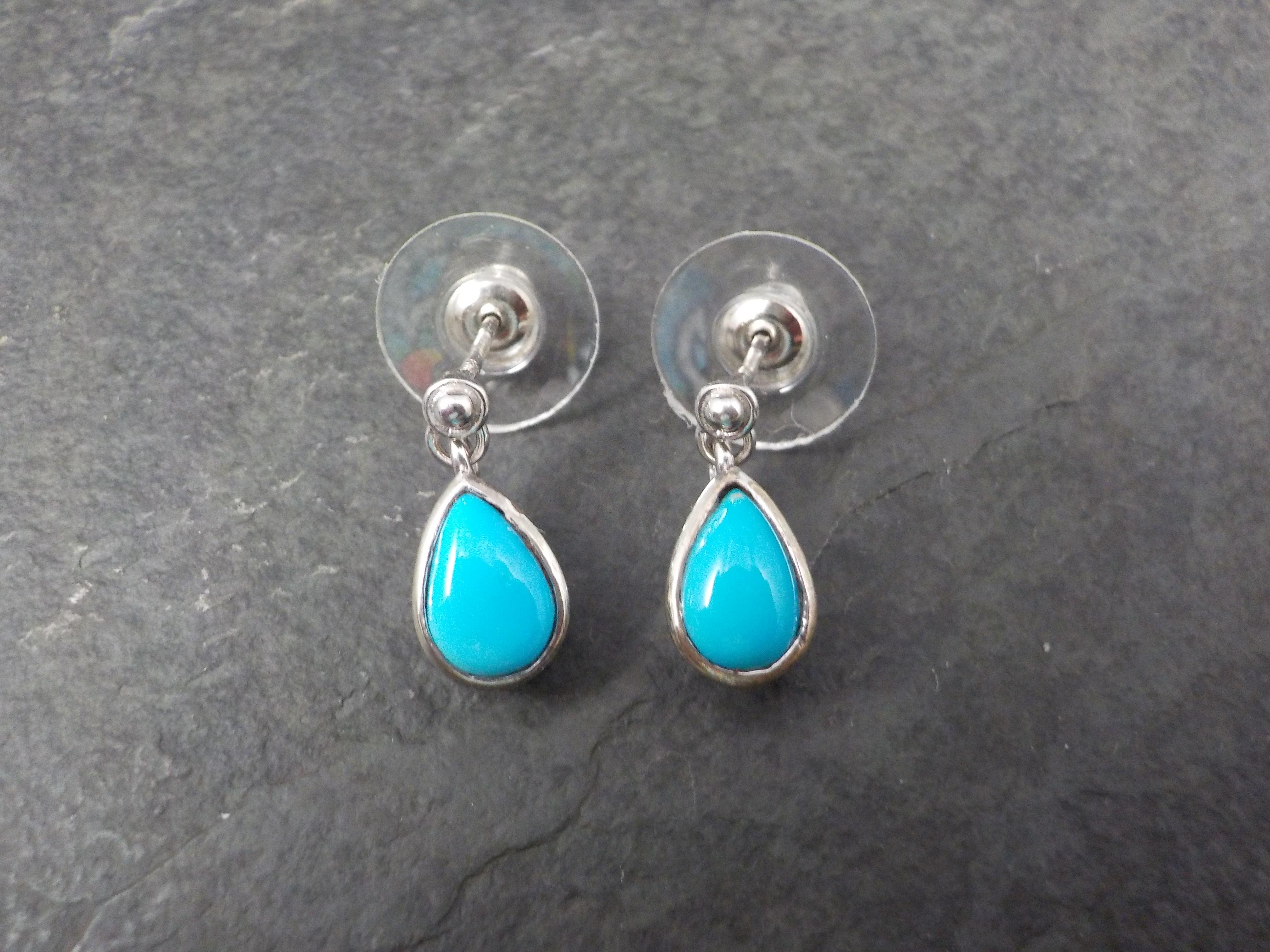 These beautiful earrings are sterling silver with genuine 6x9mm turquoise gemstones.
Measurements: 1/4 by 11/16 of an inch
Weight: 1.8 grams
Marks: 925, Chuck Clemency's STS hallmark
Condition: New old stock
