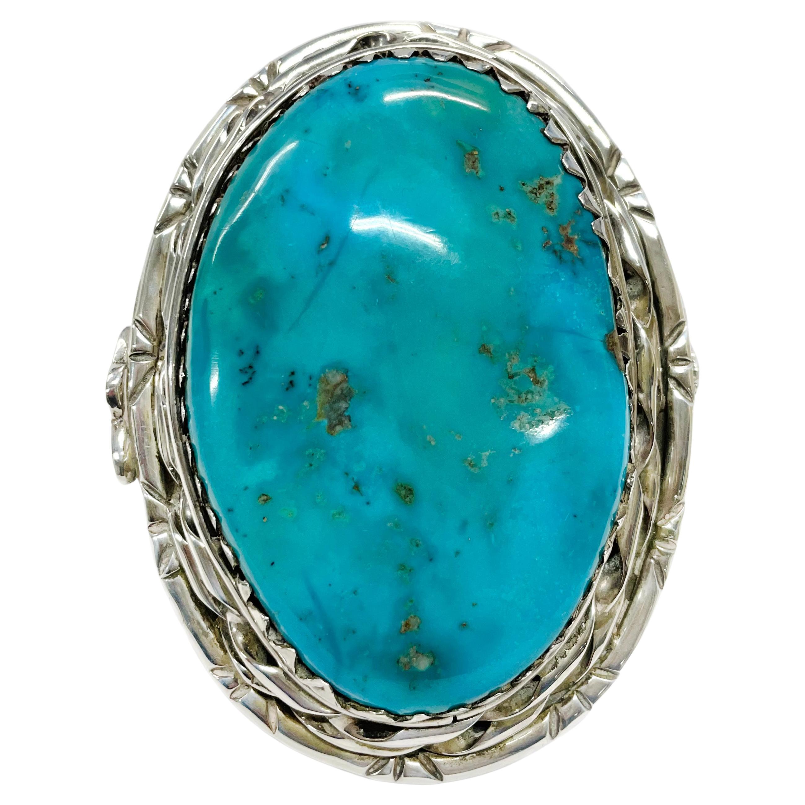 Handcrafted Sterling Silver cuff with an enormous 94mm x 63mm genuine turquoise stone. The stone is from the Castle Dome mine in Arizona. A truly unique larger than life cuff bracelet with a turquoise and carnelian thunderbird design on each side