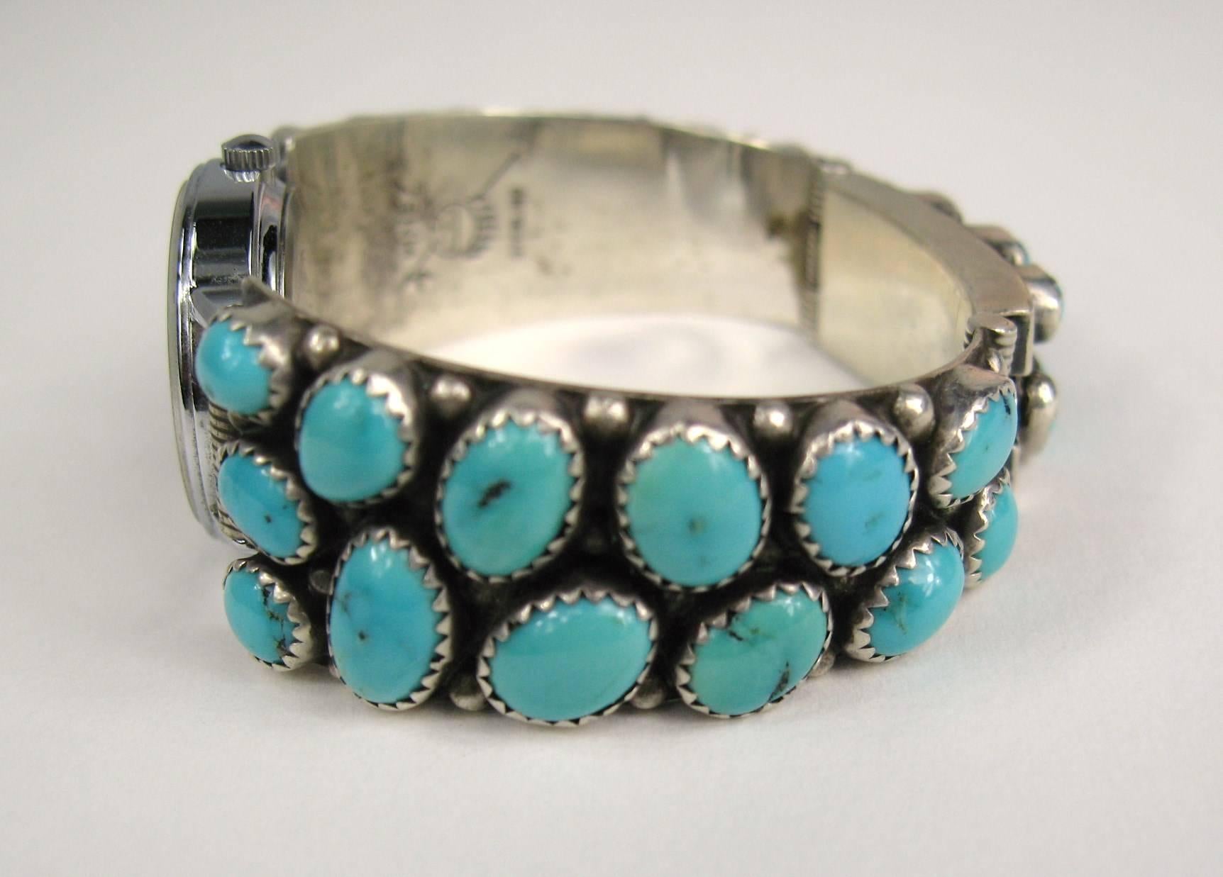 This Native American Sterling silver watch is covered in various size turquoise stones. Measuring .75 down to .50 on the band. We fit a size 6-6.25 inch wrist. Slide-in clasp closure in the back. This is out of a massive collection of Hopi, Zuni,