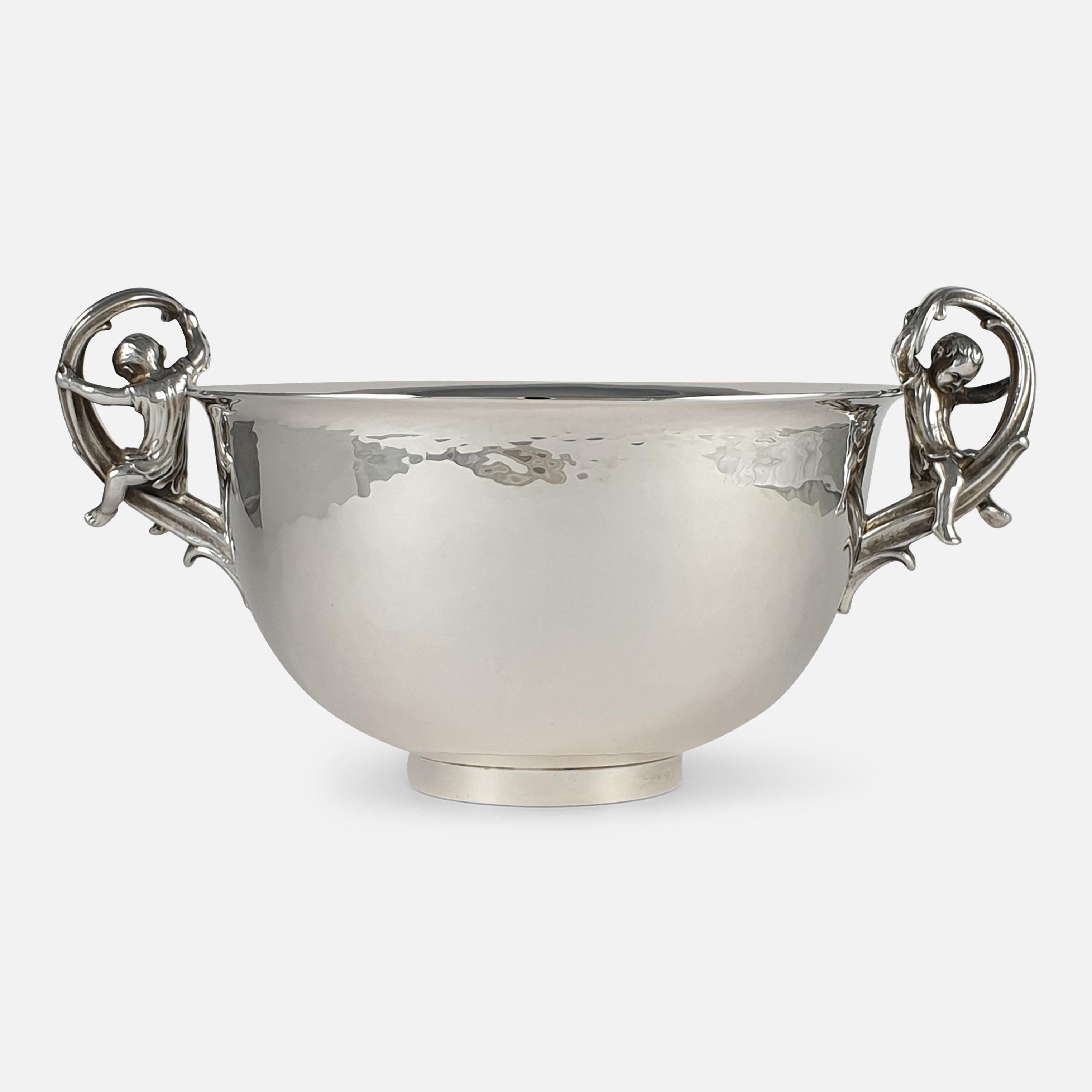 A sterling silver twin-handled bowl by Leslie G. Durbin. The bowl is of circular form, the scroll handles mounted with children, one having a splint, spot hammered decoration, on a circular foot. It is hallmarked London, 1982.

Assay: - .925