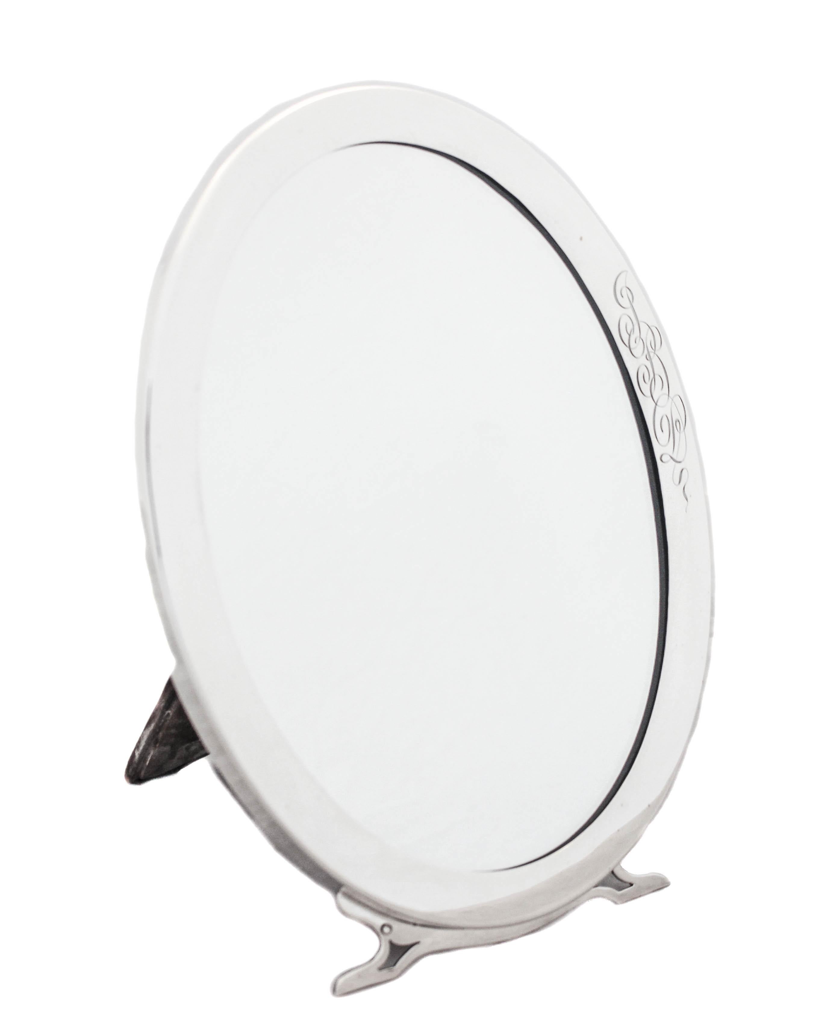 Being offered is this sterling silver table vanity mirror.  Made by George Henckel & Company of New York in 1940.  The simplicity and lack of decorative work reflect the austerity of that period.  On the bottom, the feet have an Art Deco style and