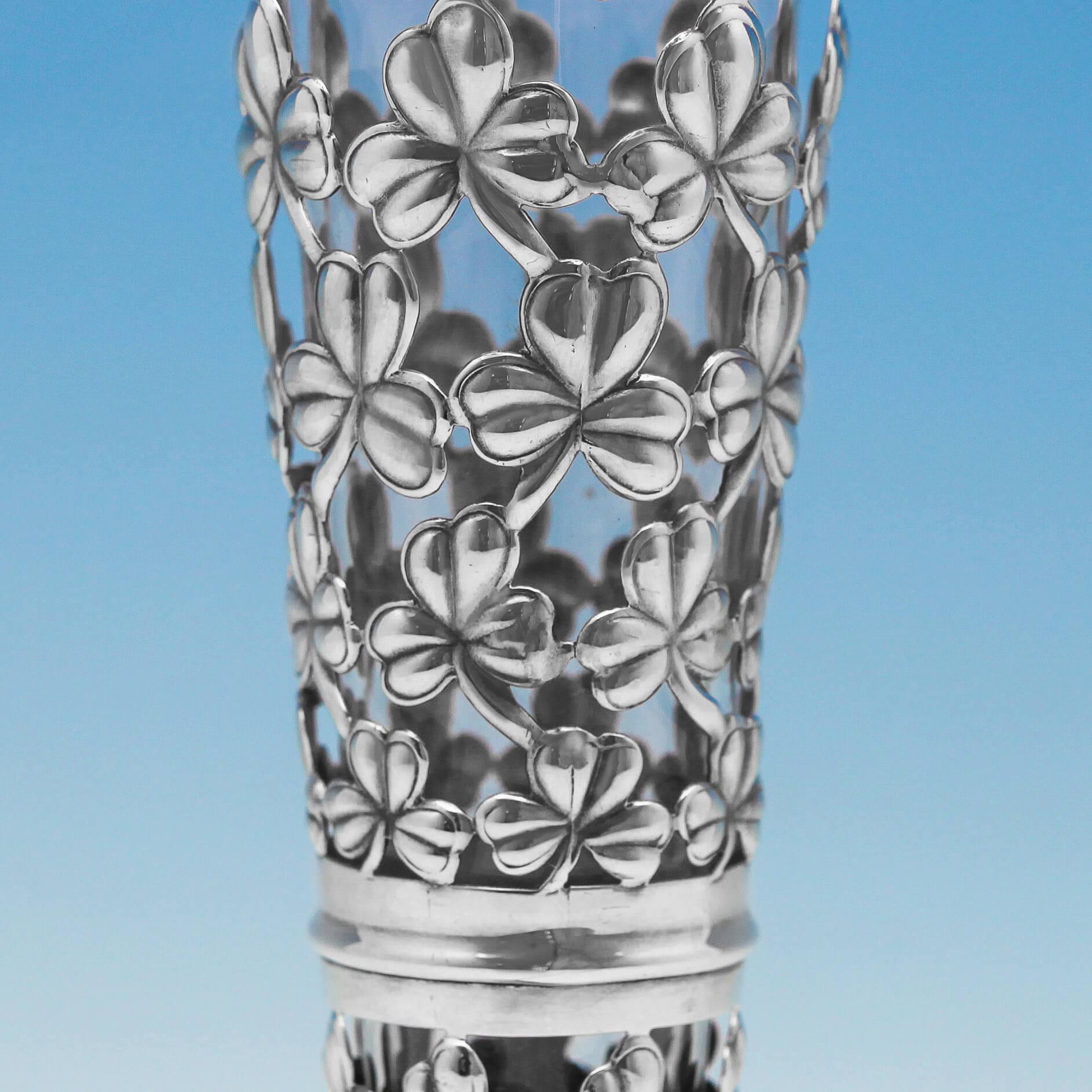 Hallmarked in Birmingham, 1905 by Martin & Hall, this delightful, Edwardian, Antique, Sterling Silver Vase, has pierced decoration to the body with a clover design, and a clear glass liner. The vase measures 9
