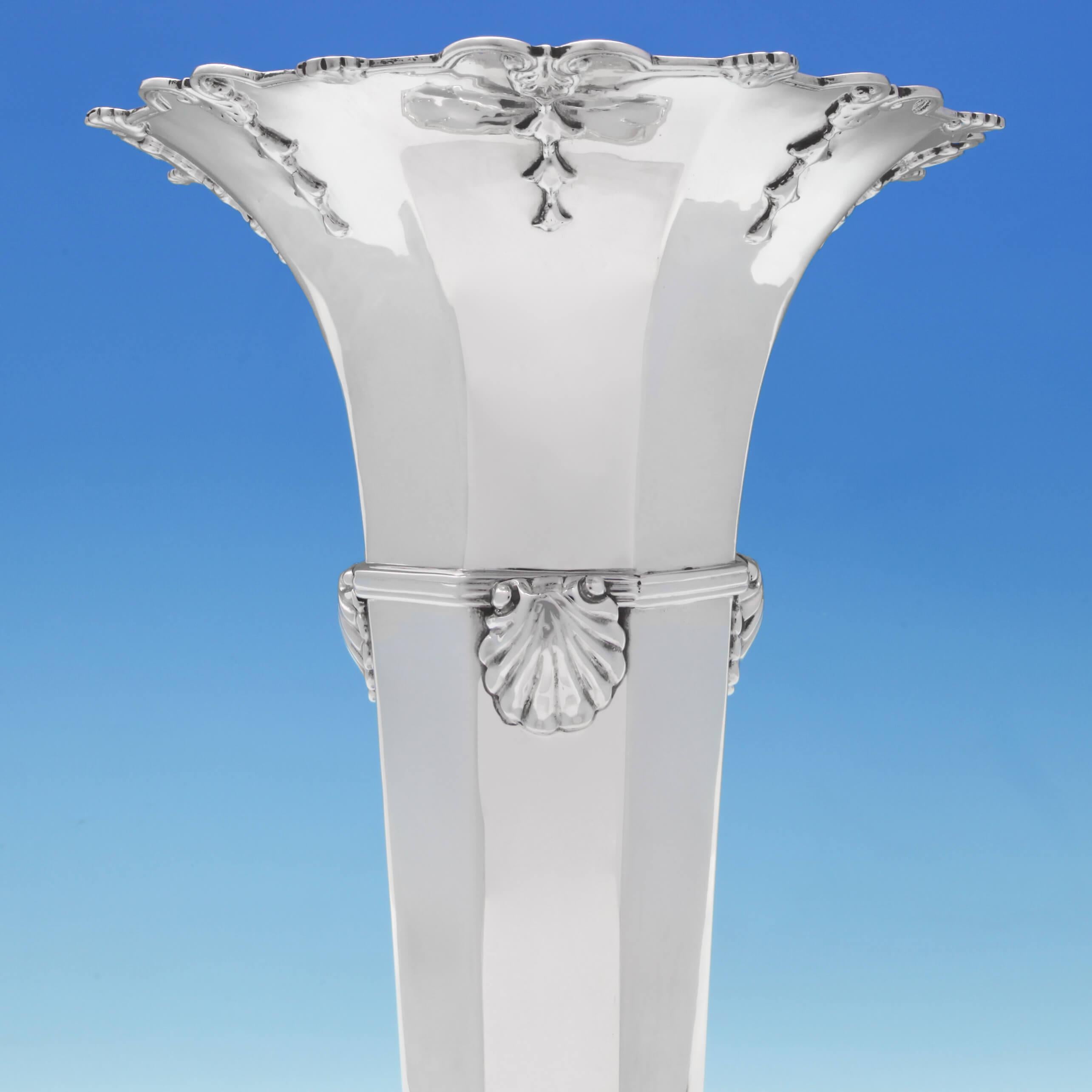 Hallmarked in London, in 1906, by William Comyns, this attractive, antique, Edwardian, sterling silver vase, has an octagonal panelled body with a reed and shell band around it, and applied decoration to the base and rim. The vase measures 14