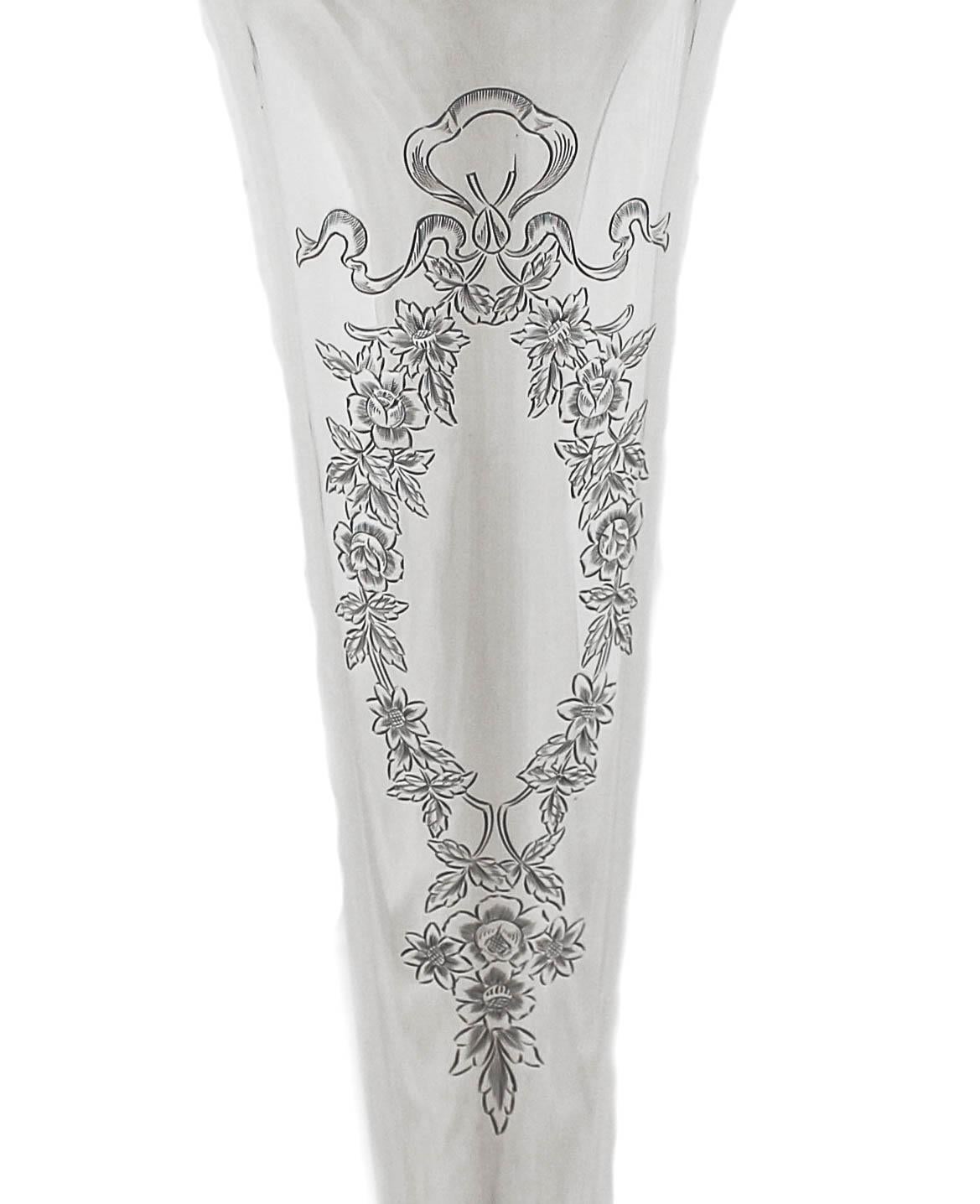 Nous avons le plaisir de vous offrir ce vase en argent sterling.  Il est haut et mince, avec une forme effilée. Un magnifique cartouche floral attend votre monogramme personnalisé.  En dehors de cela, il n'y a pas de gravures décoratives.  Ce vase