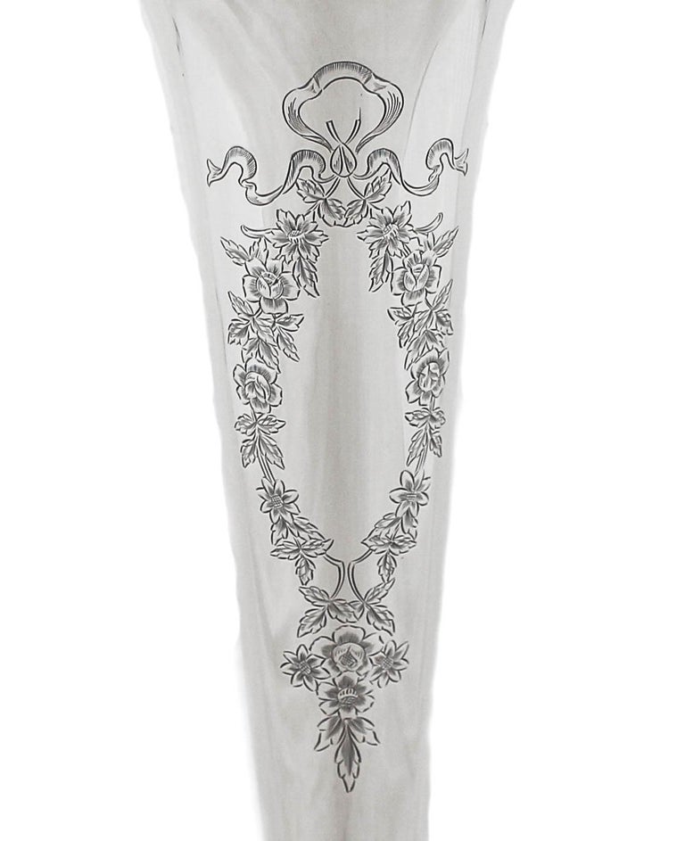 We are delighted to offer you this sterling silver vase.  It is tall and slim with a tapered shape. A beautiful floral cartouche awaits your personalized monogram.  Other than that there are no decorative etchings to be found.  This vase is NOT