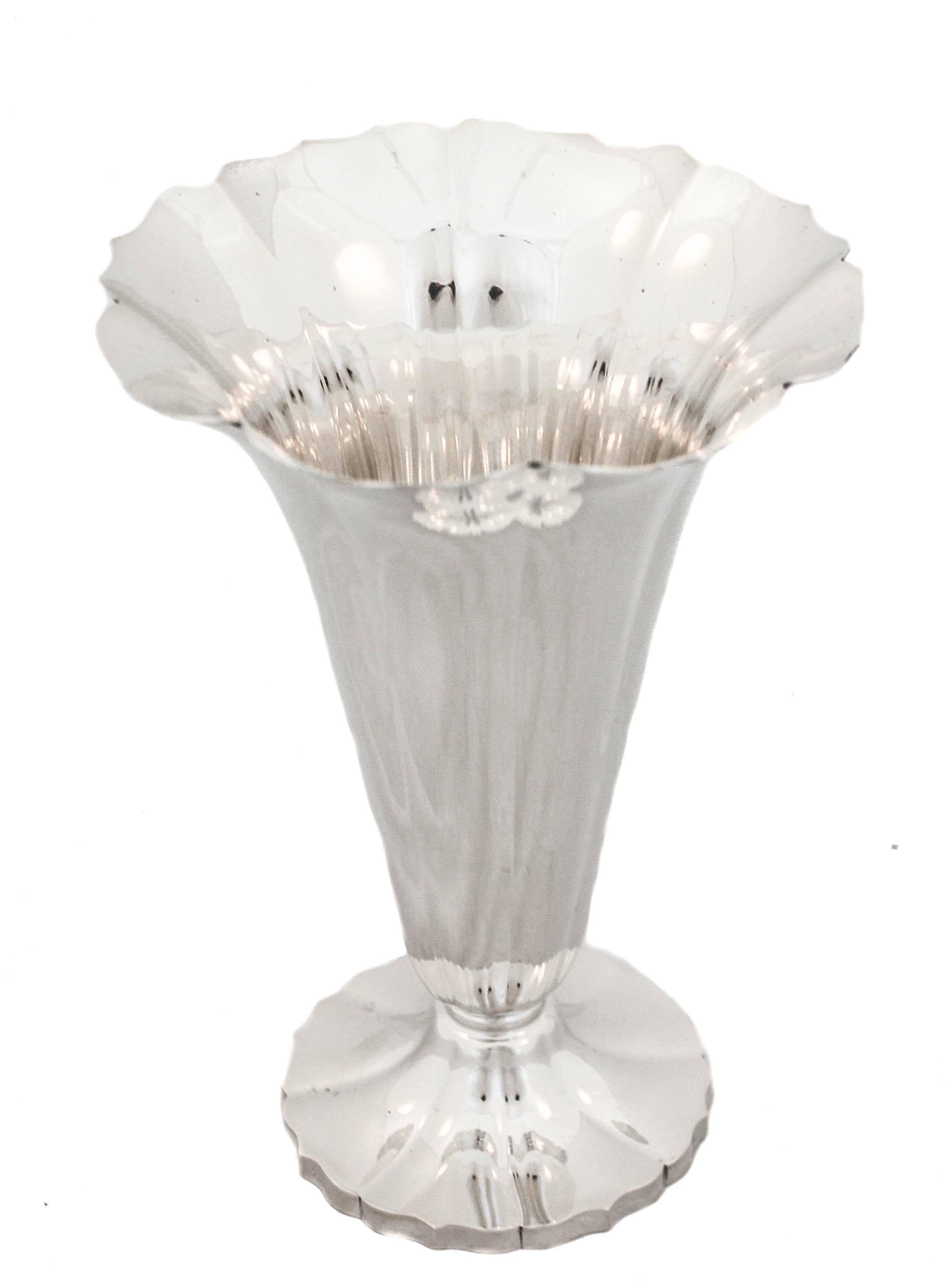 This sterling silver vase will add elegance to any room and decor. It has a scalloped rim that opens outwards mimicking a budding flower. Sleek and contemporary it can be used in a bedroom, foyer or powder room. The base is also scalloped thereby