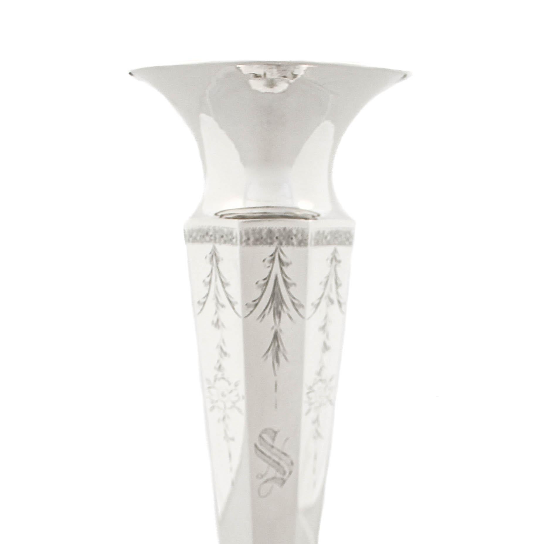 Being offered is a sterling silver vase by Victor Siedman Silver of New York.  It has a paneled design and the base (not weighted) is octagonal to mimic the body (sided).  The vase is tapered and the rim opens outwards, allowing the flowers to
