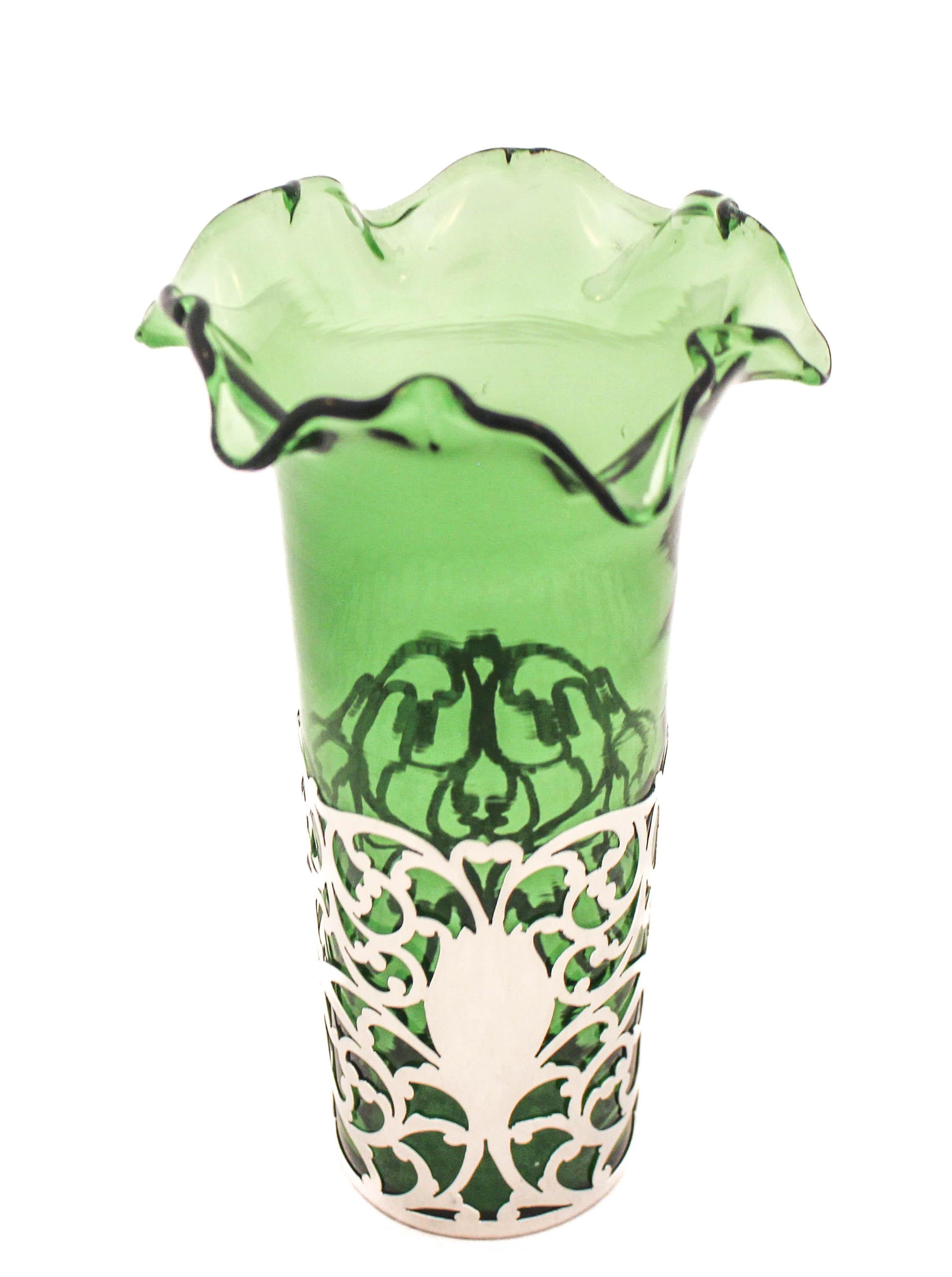 Being offered is a sterling silver vase with an emerald-green glass liner.  The glass has a fluted rim and comes out of the silver, for easy cleaning.   The sterling is reticulated and allows the emerald glass to shine through it.  There’s even a