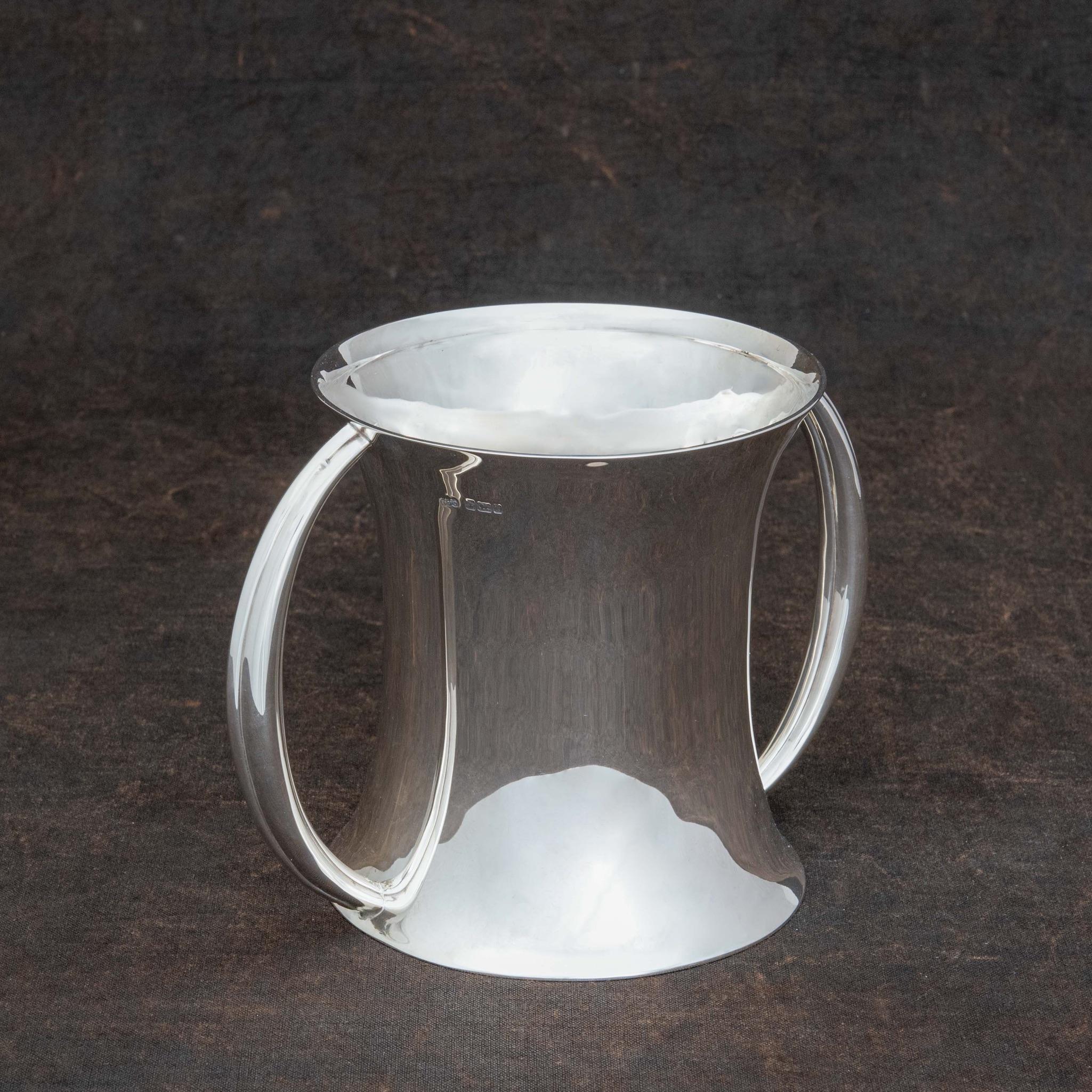 Elegante jarrón o cubitera inglesa de plata de ley con dos asas de lengüeta. Tiene la marca del fabricante Elkington & Co. Hallmarked Sheffield 1903.

Dimensiones: 13 cm/5⅛ pulgadas (diámetro en la parte superior, sin incluir las asas) x 14 cm/5½