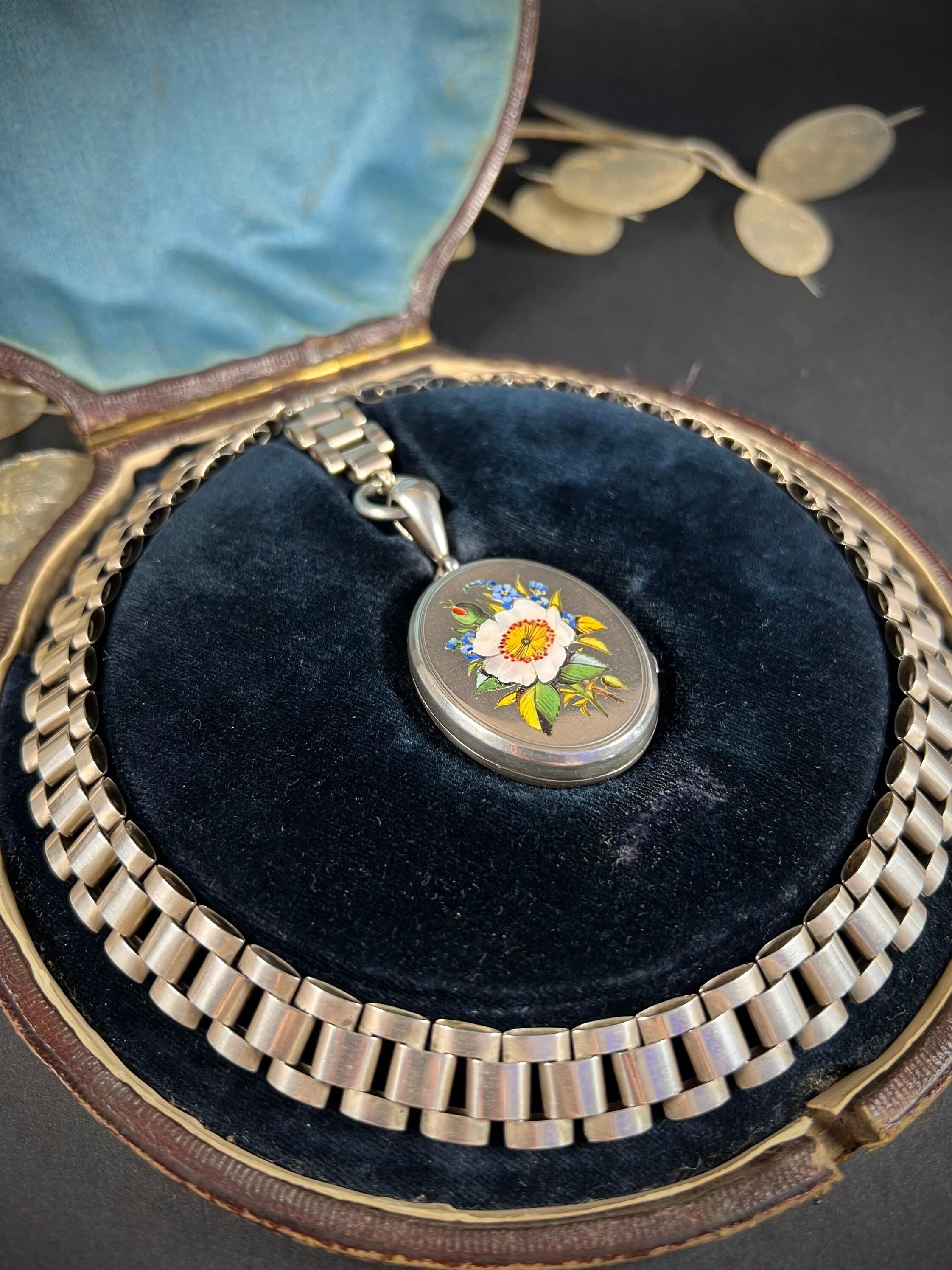 Antique Book Chain Necklace 

Sterling Silver 

Circa 1880

The most fabulous example of Victorian craftsmanship. Lovely, chunky silver links, joined by a large bolt ring clasp. Features a beautiful, large silver locket. Beautifully decorated with