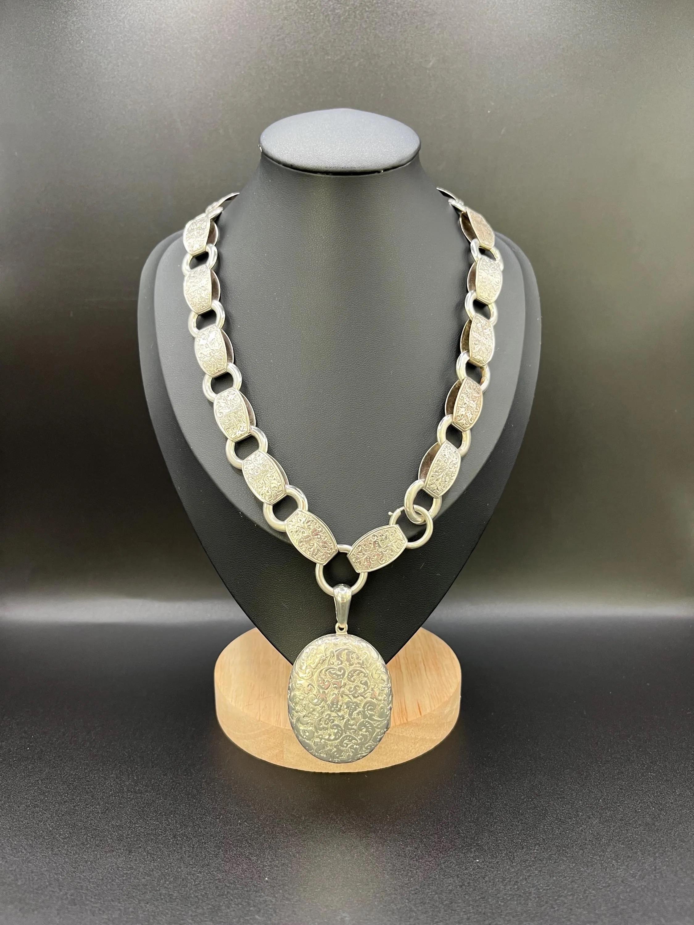 Collana a catena e medaglione con libro antico

Argento 

Circa 1880

Medaglione e catena in argento tardo-vittoriano finemente lavorati, risalenti al 1880 circa. Il medaglione ovale presenta motivi a volute e a fogliame profondamente incisi, tipici