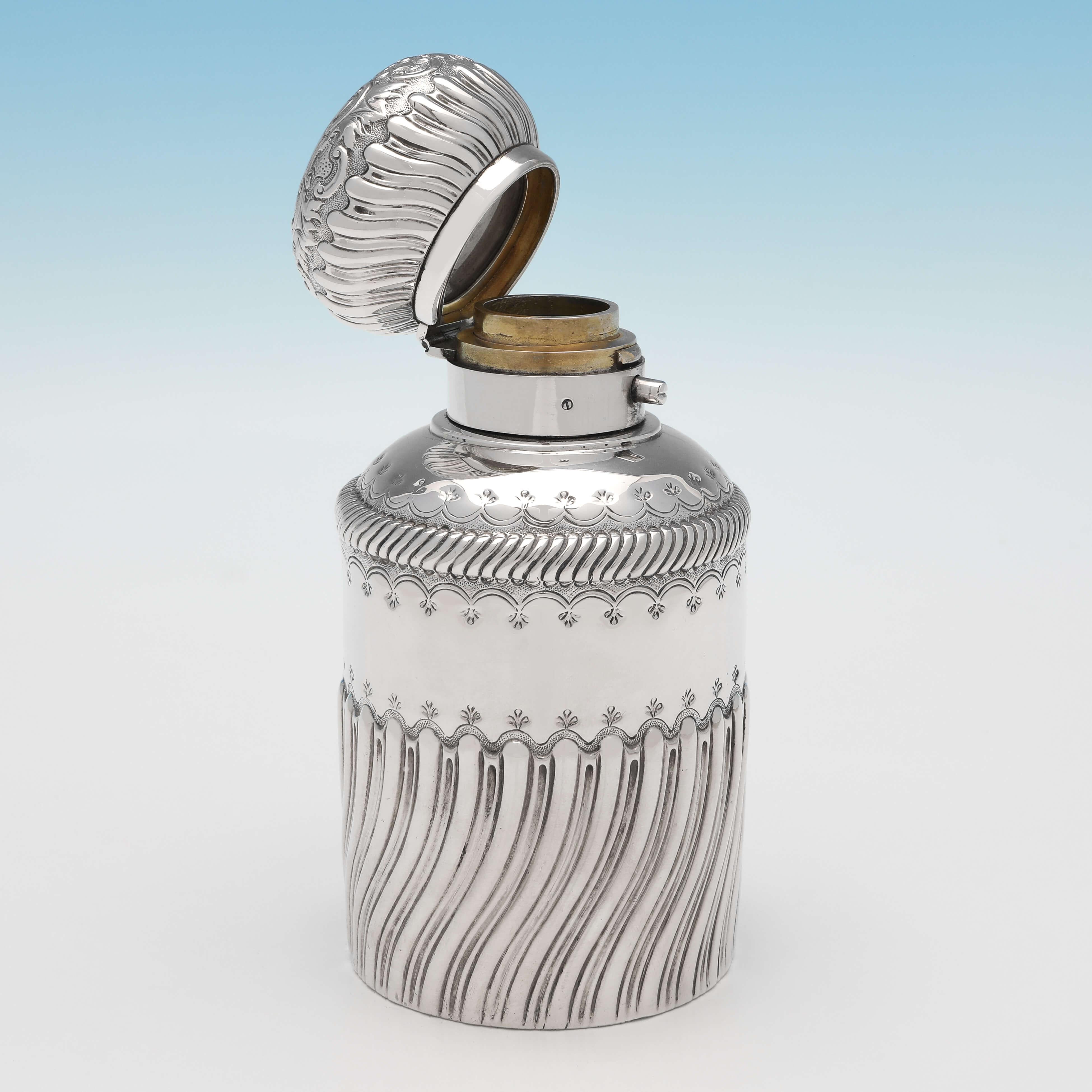 Hallmarked in London in 1885 by George Brace, this unusual, Victorian, Antique Sterling Silver Scent Bottle, features a silver body and lid, both decorated with sunken and swirled fluting, and engraved detailing. The scent bottle measures 5.5