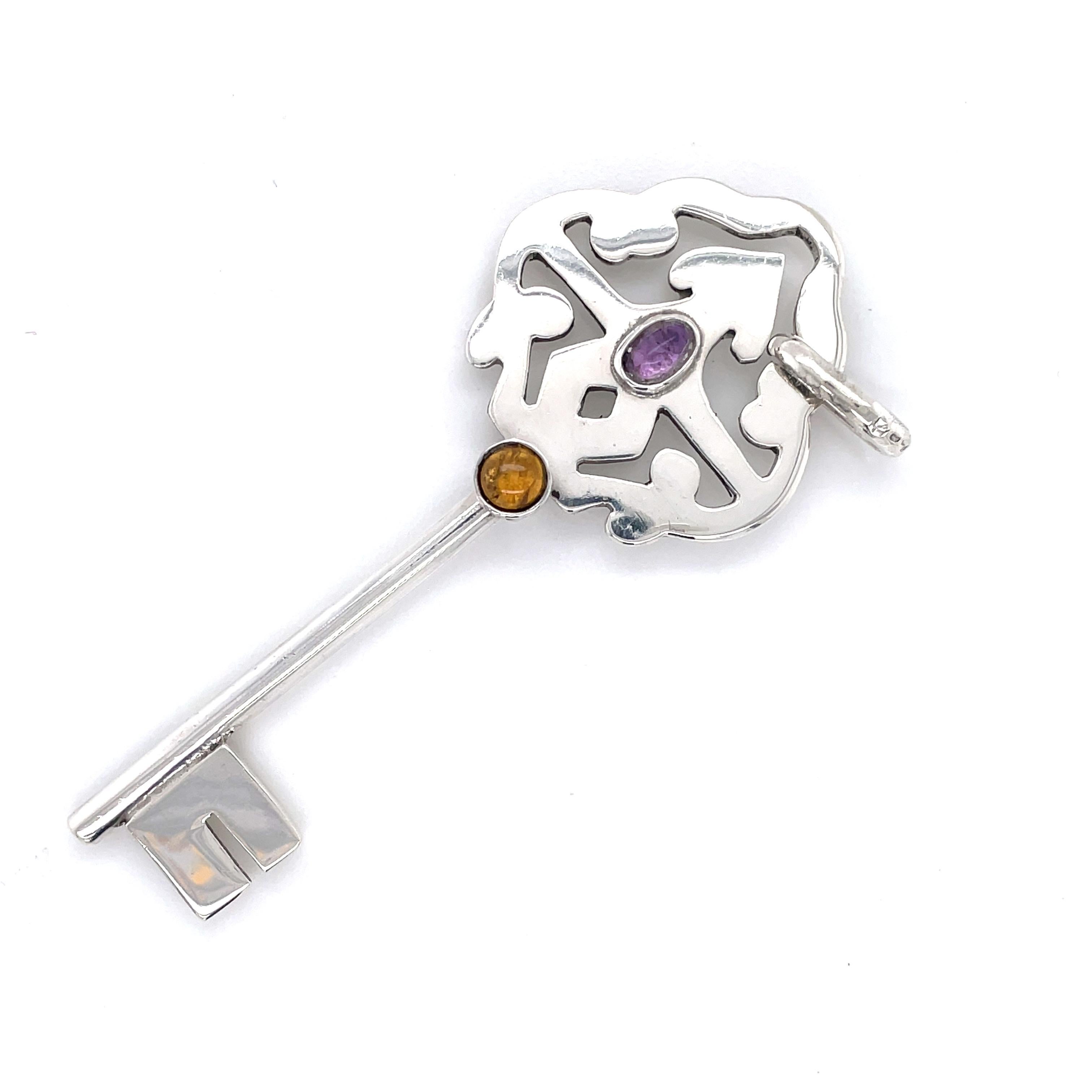 This fun vintage sterling silver key charm makes a unique addition as a pendant for one of your longer chains or added to a key ring. Measuring at three inches, this silver charm has a pop of color accented with an amethyst and a citrine cabochon.